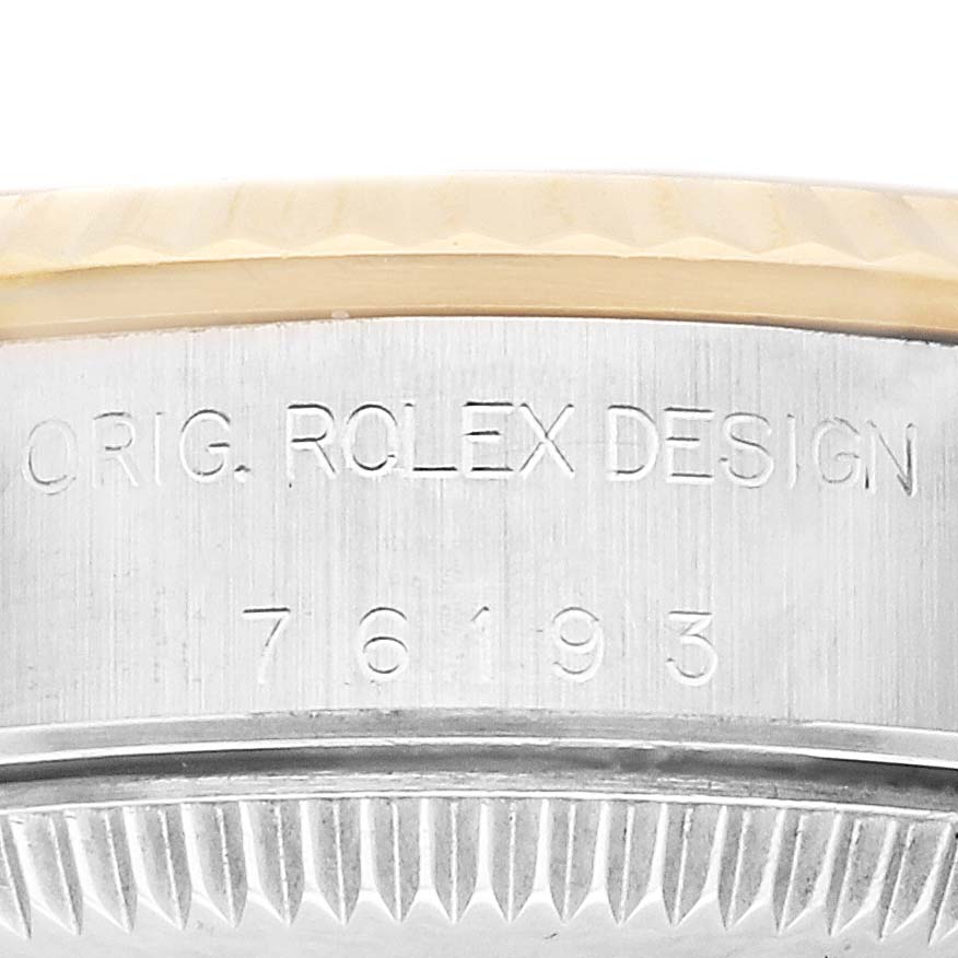 This image shows a close-up of the engravings on the side of the case of a Rolex Oyster Perpetual 76193 Women's Stainless Steel Grey Dial 76193 Women's Stainless Steel Grey Dial watch, displaying "ORIG. ROLEX DESIGN 76193".