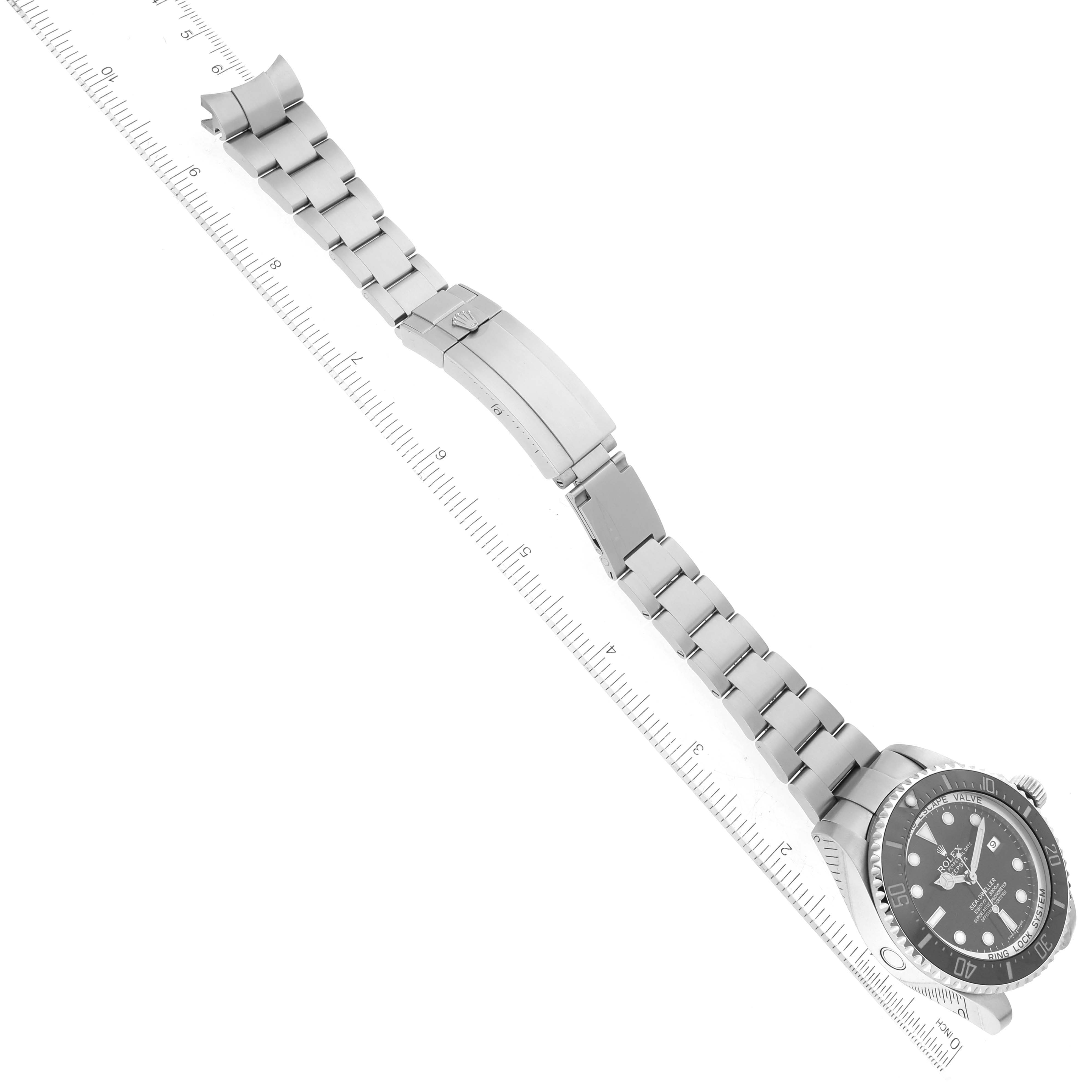 This image shows a Rolex Sea-Dweller 116660 Men
s Stainless Steel Black Dial 116660 Men
s Stainless Steel Black Dial watch laid flat, revealing the face, bezel, bracelet, and clasp, aligned next to a ruler.