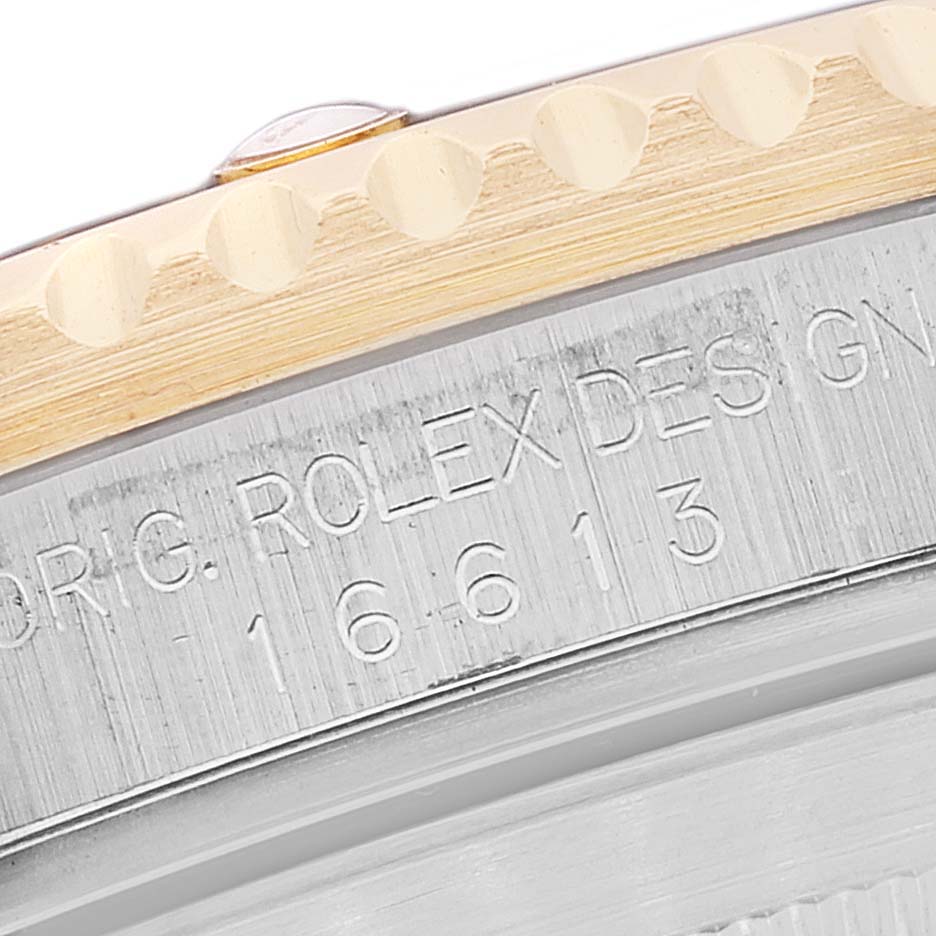 The image shows a close-up of the case side and engraved serial number on a Rolex Submariner 16613 Men
s Steel and Gold (two tone) Blue Dial 16613 Men
s Steel and Gold (two tone) Blue Dial watch.
