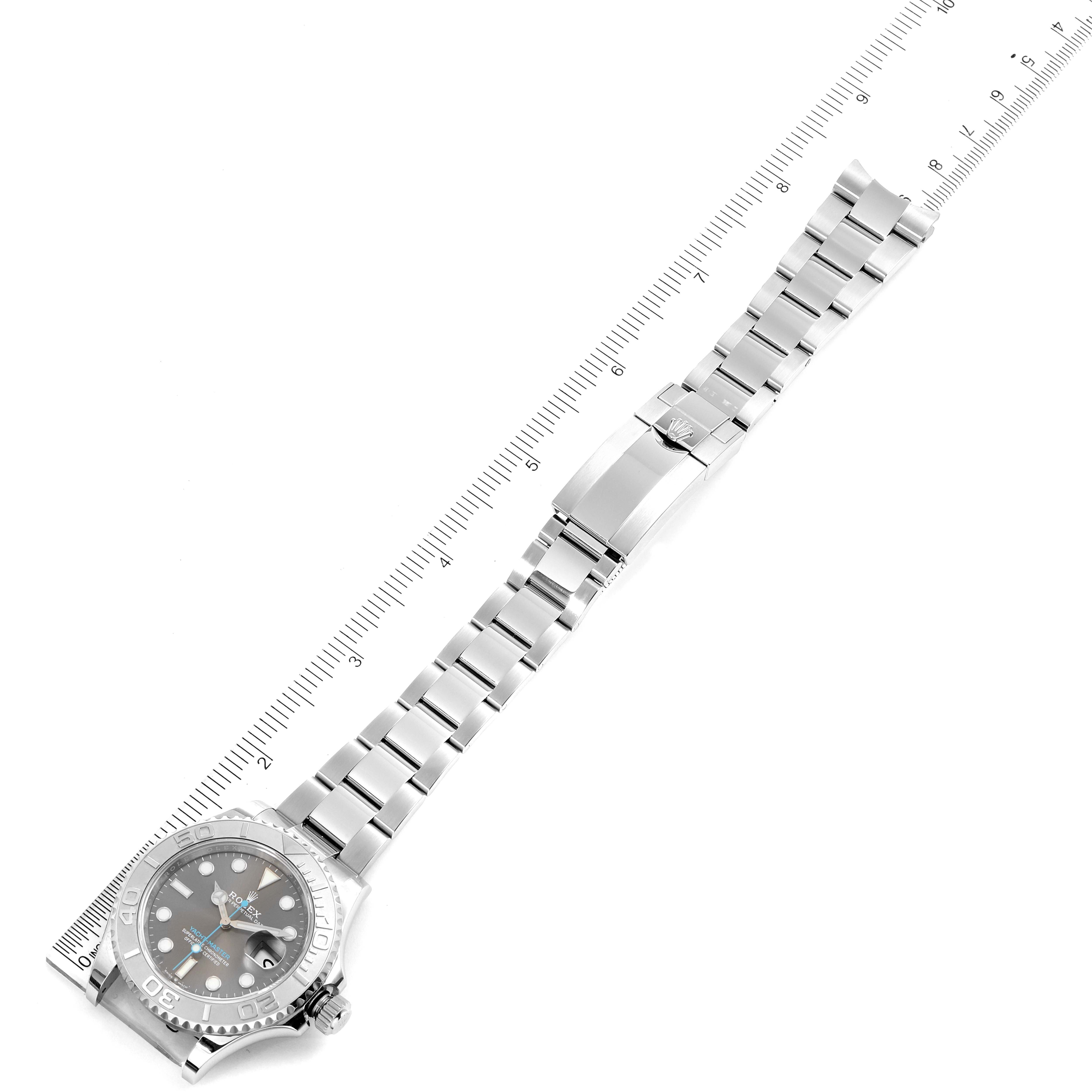 The image shows a top view of a Rolex Yacht-Master 126622 Men
s Stainless Steel Grey Dial 126622 Men
s Stainless Steel Grey Dial watch with its bracelet fully extended and a ruler for measurement.