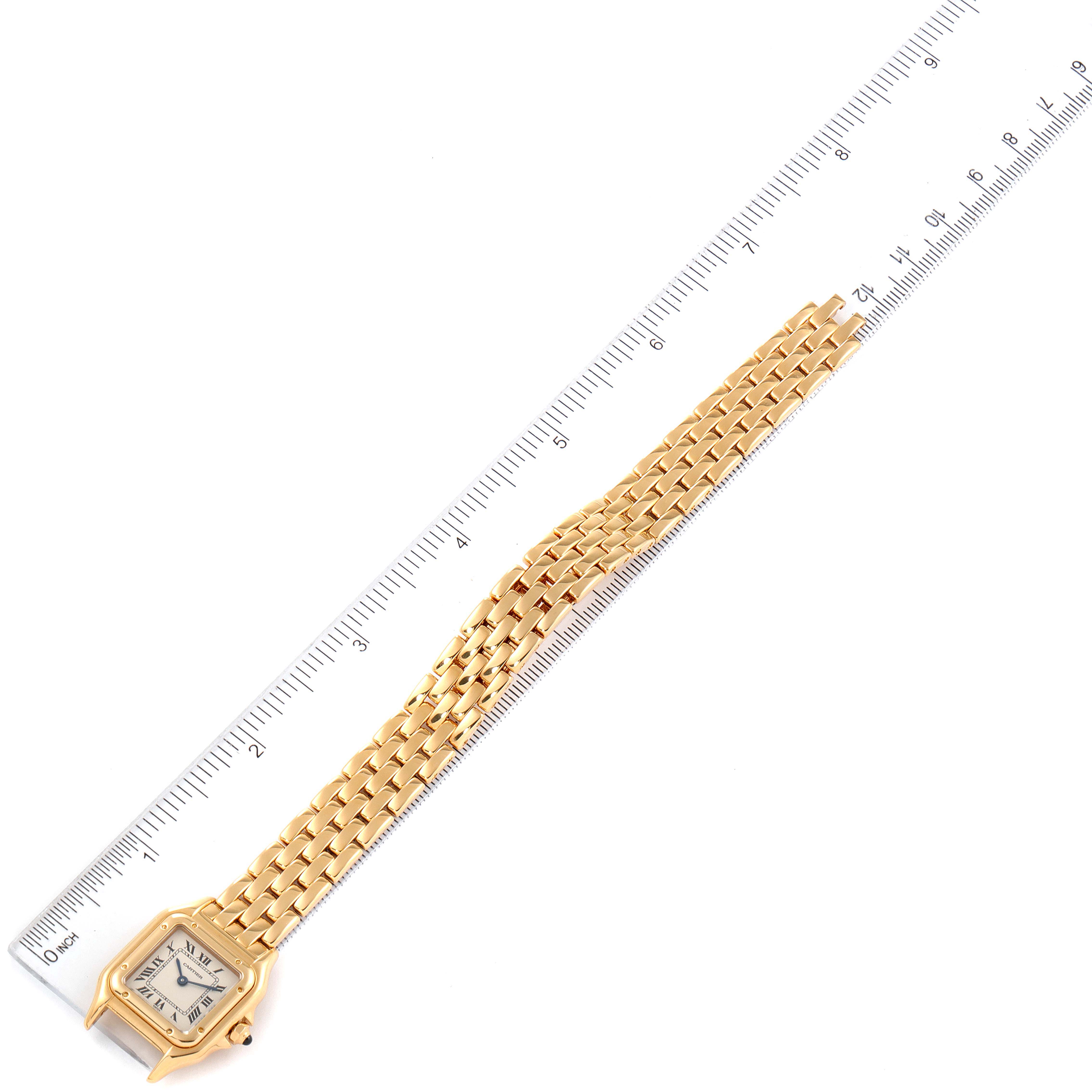 The image shows a Panthère de Cartier watch laid flat next to a ruler, highlighting the bracelet and case.
