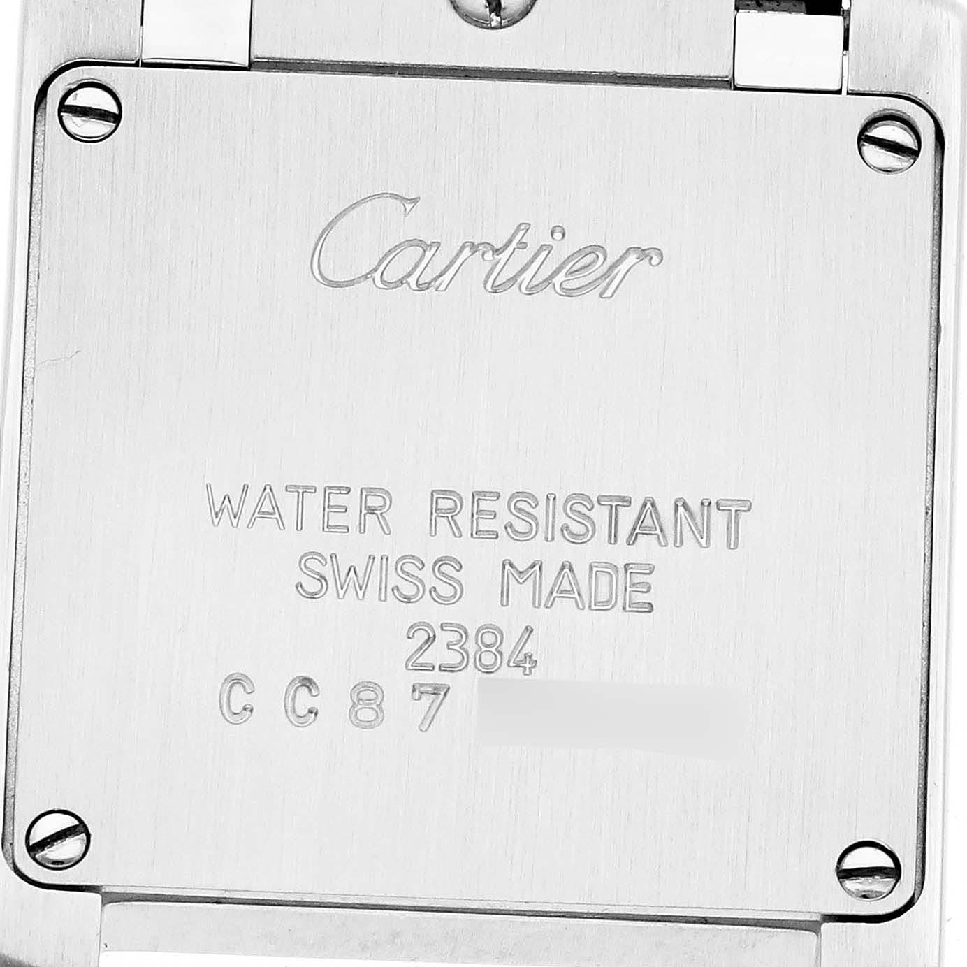 The image shows the back of a Cartier Tank Française watch with engraved details.