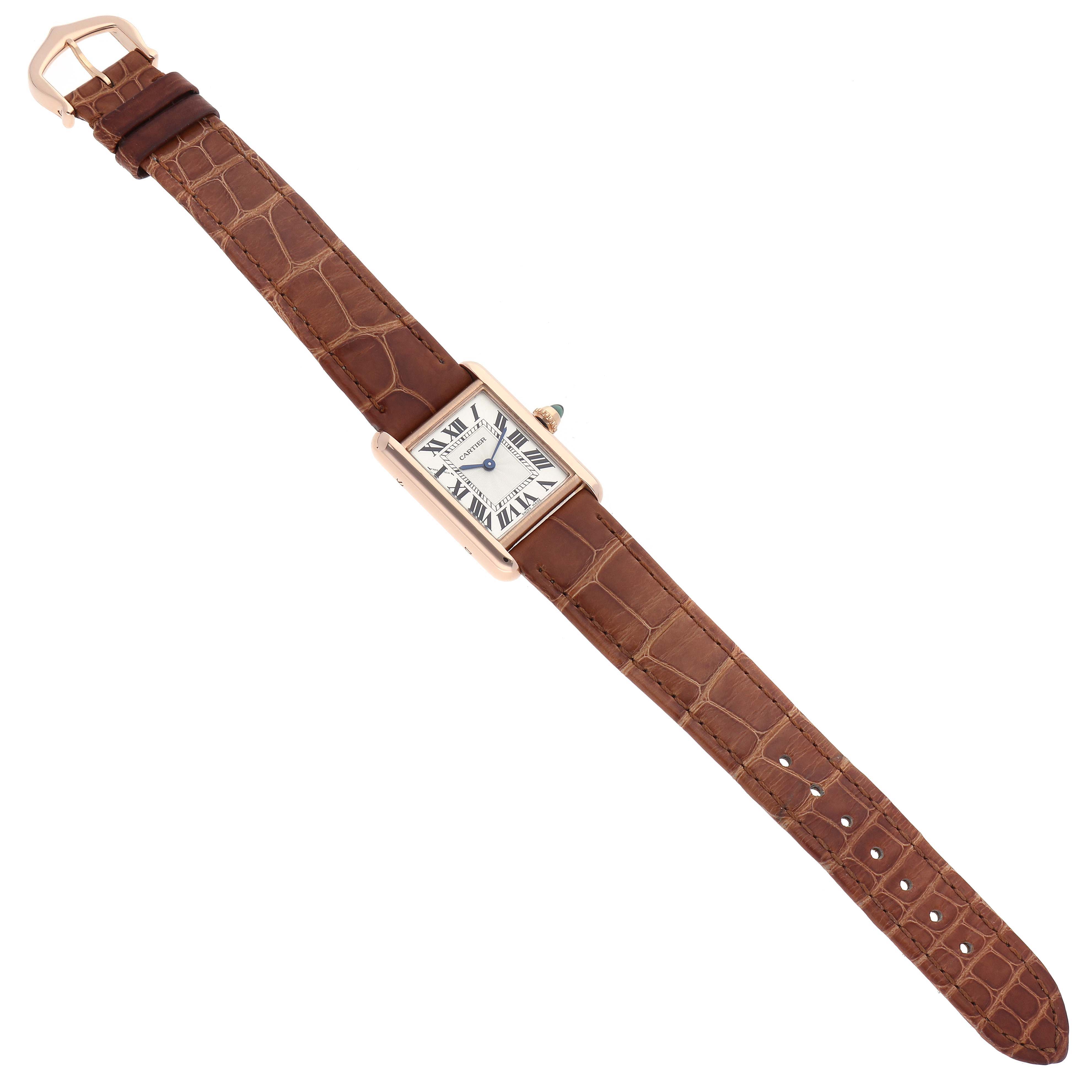 The Tank Louis model by Cartier is shown in a top view, displaying its brown leather strap, white dial with Roman numerals, and gold case.