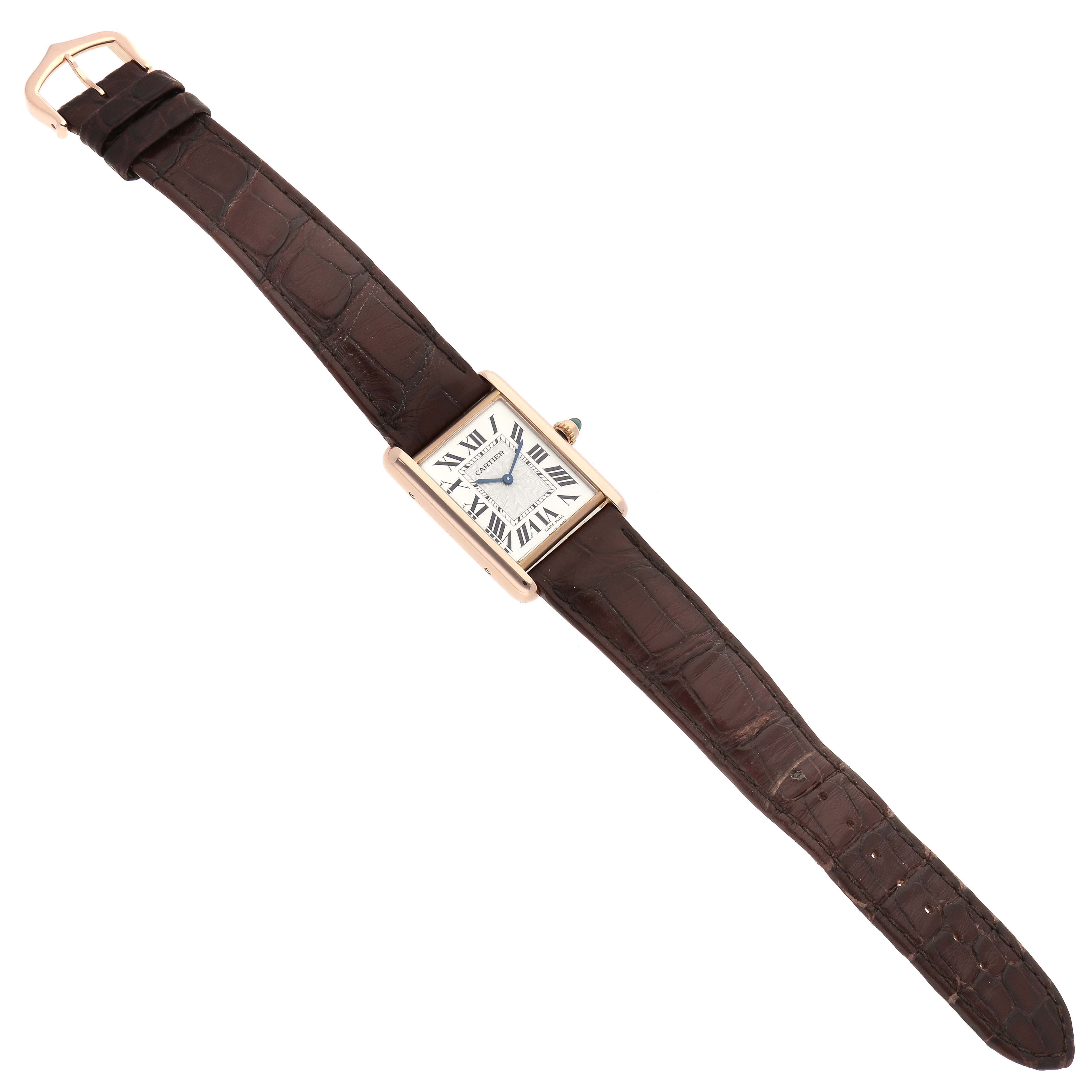 The Tank Louis Cartier watch is shown in its entirety from a top-down angle, displaying its rectangular face and brown leather strap.