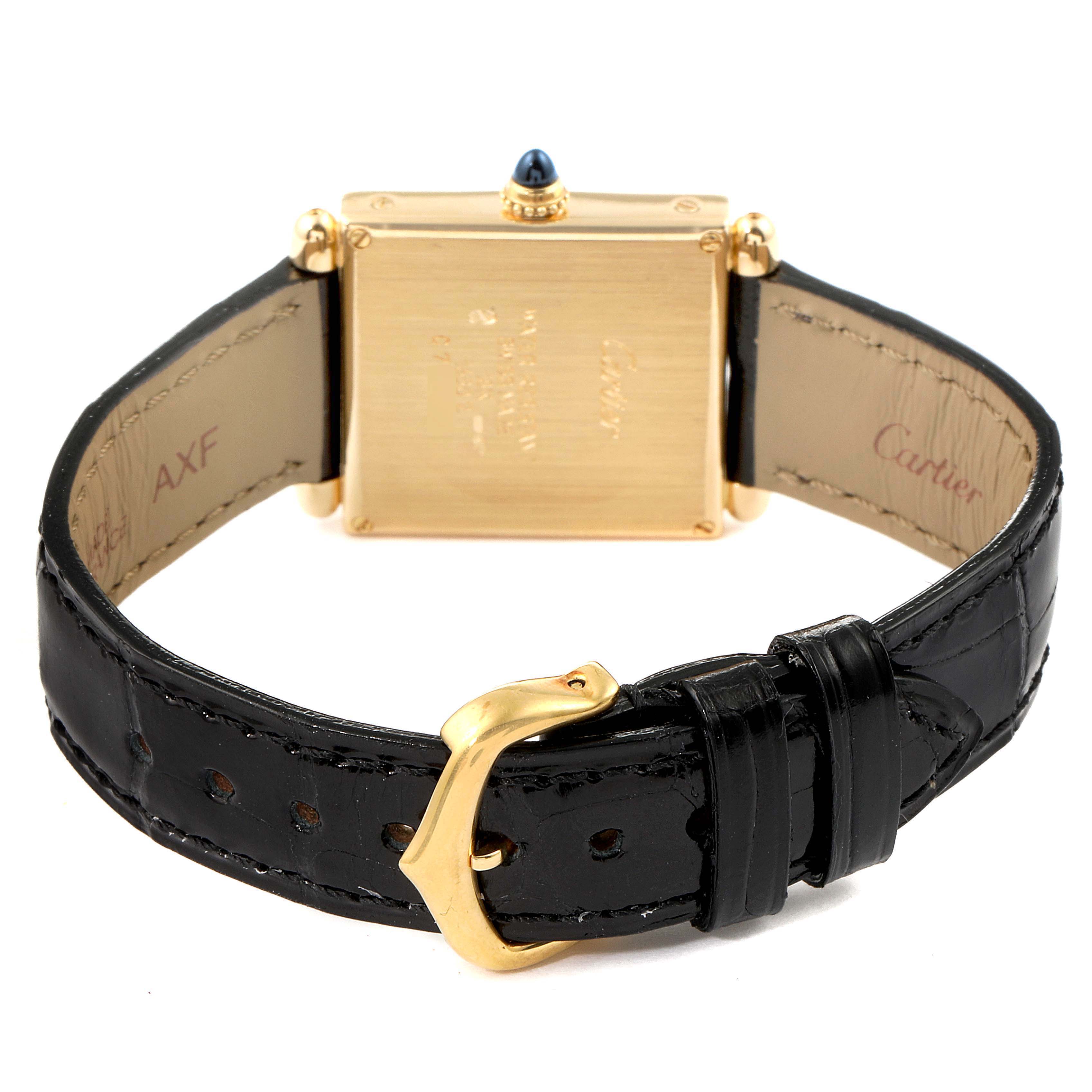 The image shows the back view of a Cartier Tank Obus 1630 Women's Yellow Gold Silver Dial 1630 Women's Yellow Gold Silver Dial watch, focusing on the case back and black leather strap with a gold buckle.