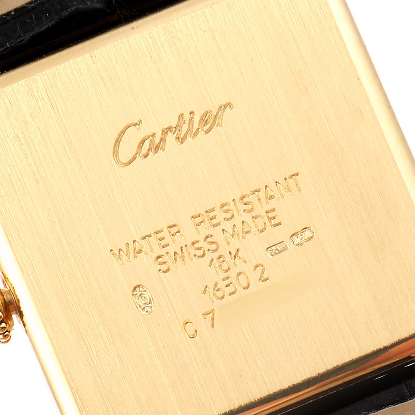 The image shows the back case of a Cartier Tank Obus 1630 Women's Yellow Gold Silver Dial 1630 Women's Yellow Gold Silver Dial watch, highlighting the engravings and gold surface.