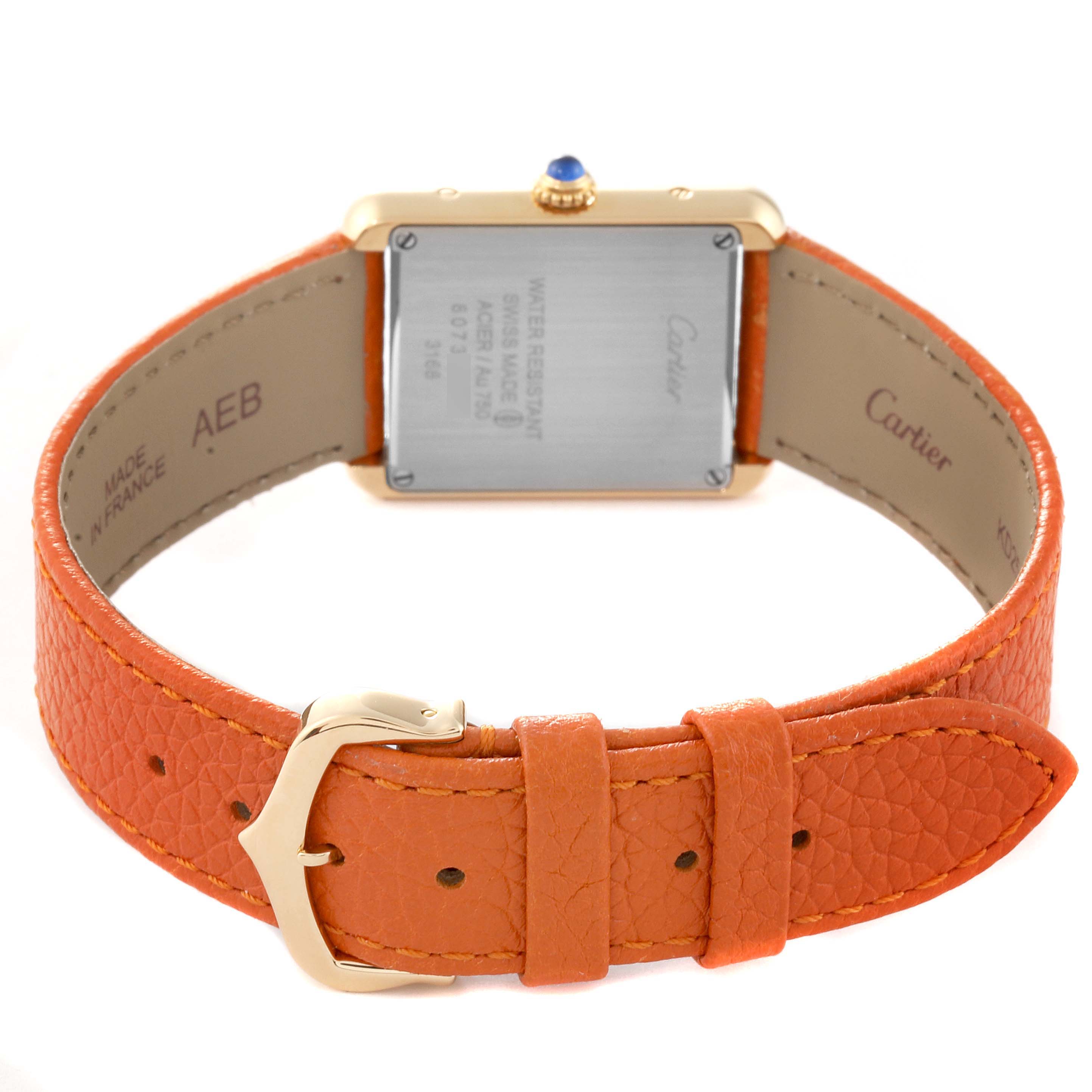 The image shows the back view of a Cartier Tank Solo W5200002 Women
s Steel and Gold (two tone) Silver Dial W5200002 Women
s Steel and Gold (two tone) Silver Dial watch, featuring its case back, orange leather strap, and buckle.