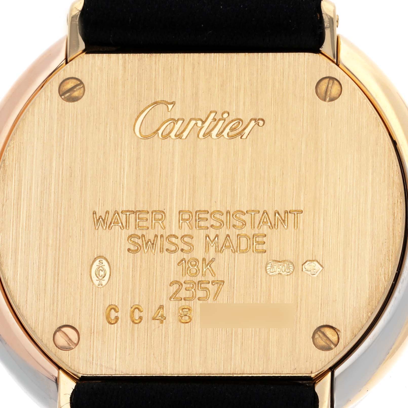 The image shows the back of a Trinity model by Cartier watch, highlighting its gold case and engraved details.
