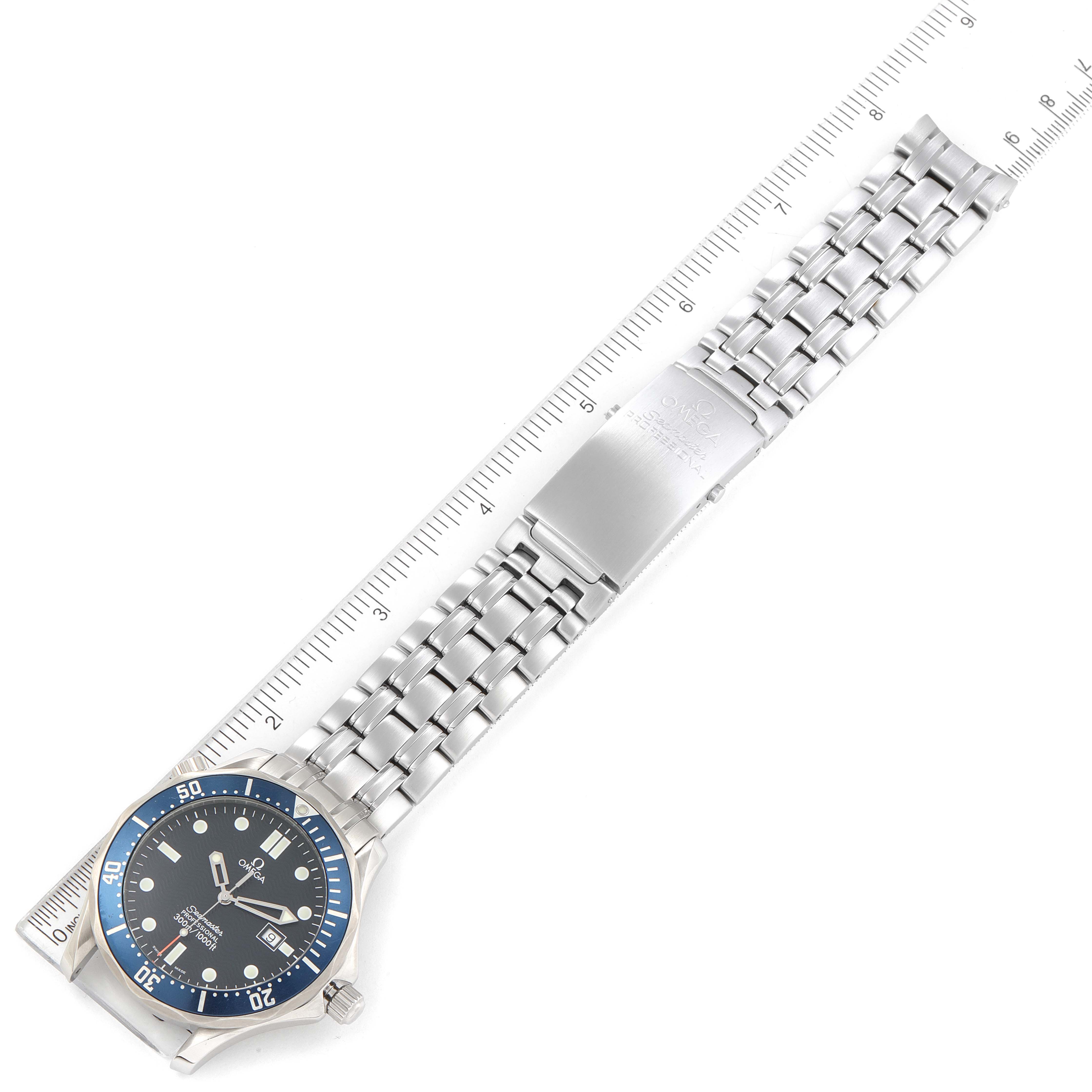 The image shows the Omega Seamaster 2541.80.00 Men's Stainless Steel Blue Dial 2541.80.00 Men's Stainless Steel Blue Dial watch in a top-down angle, highlighting the face, bezel, crown, and bracelet next to a ruler.
