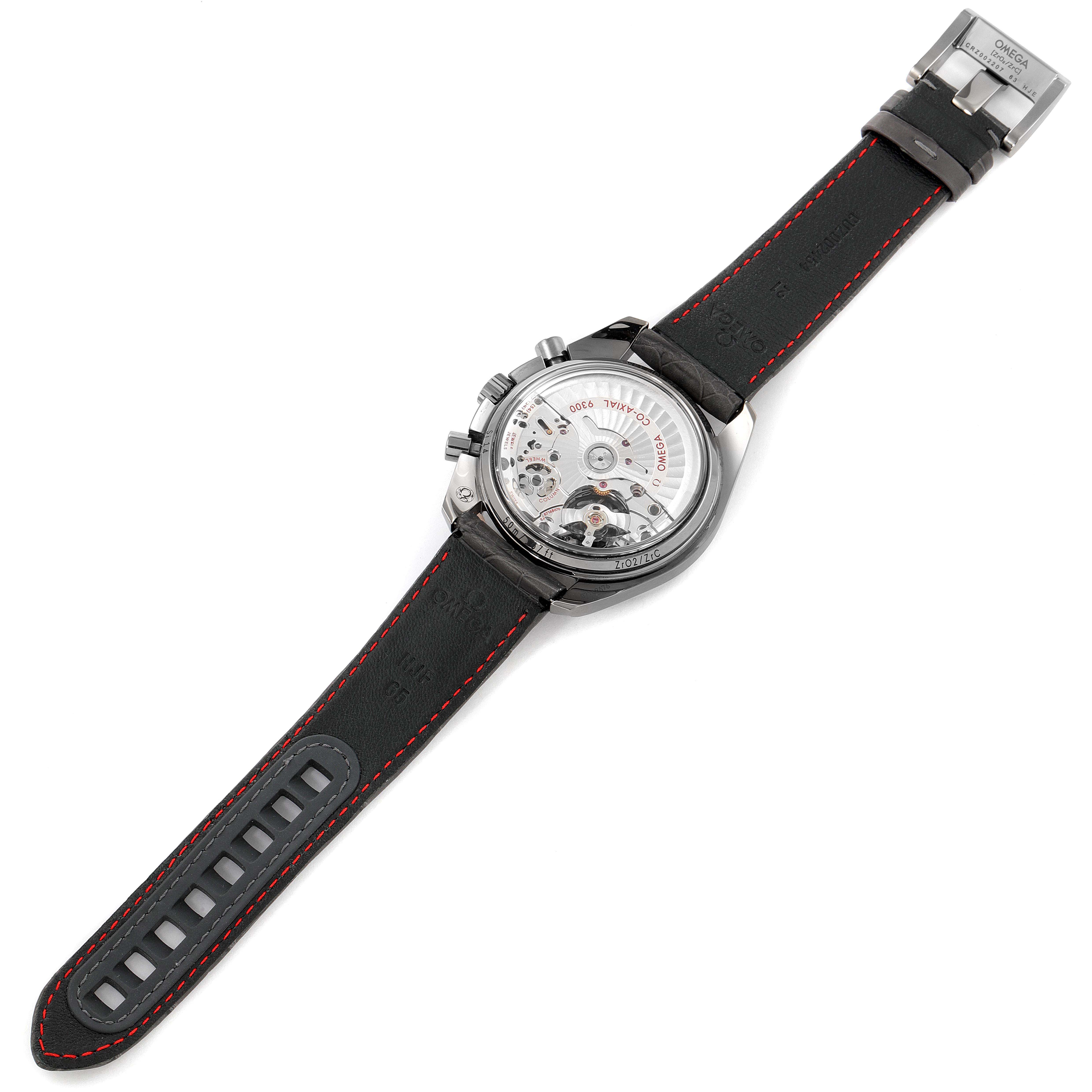 The image shows the back view of an Omega Speedmaster 311.63.44.51.99.002 Men
s Ceramic Grey Dial 311.63.44.51.99.002 Men
s Ceramic Grey Dial watch, highlighting its movement and leather strap with red stitching.