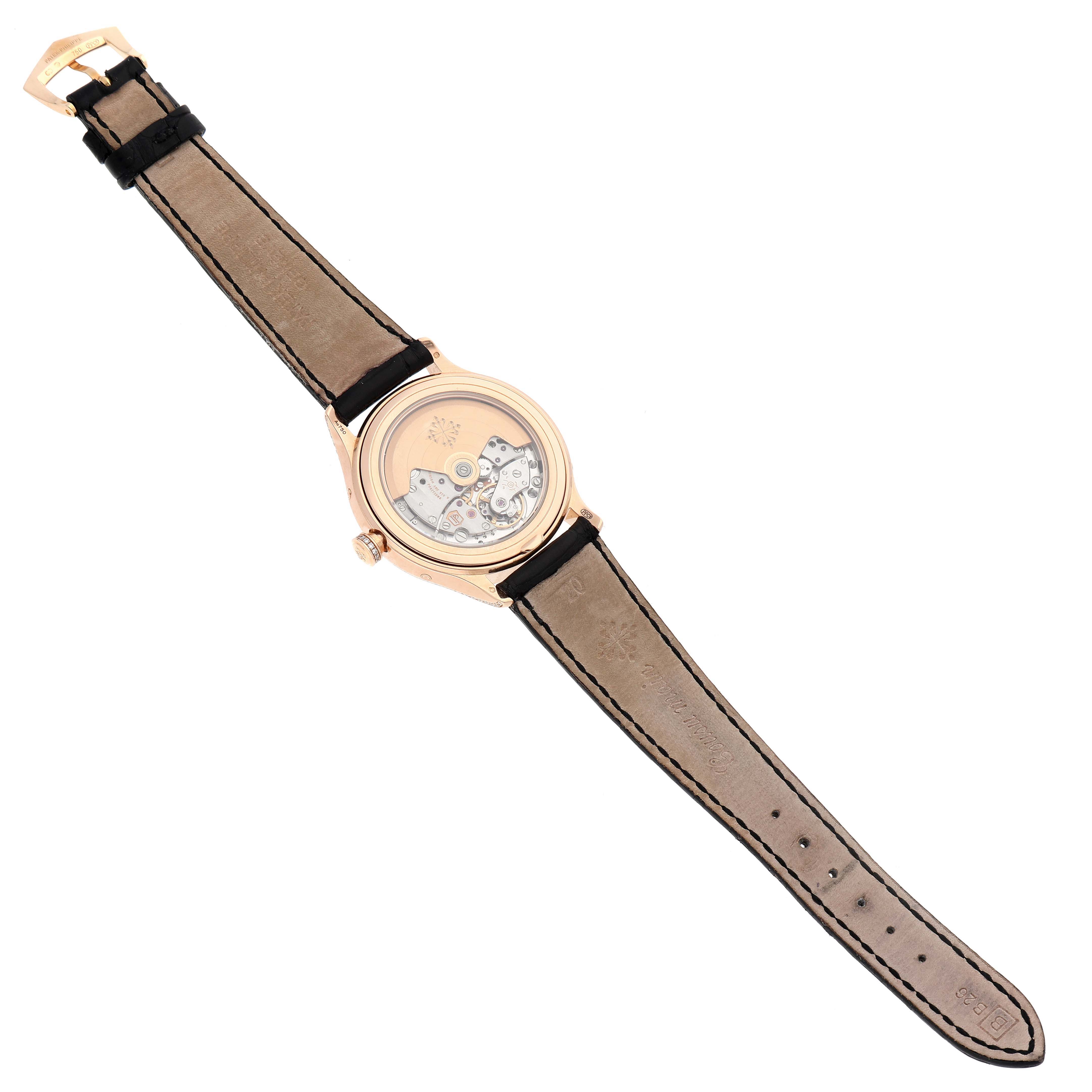 The Patek Philippe Complications 4947R-001 Men's Rose Gold Silver Dial watch is shown from the back, highlighting the transparent case back and leather strap.