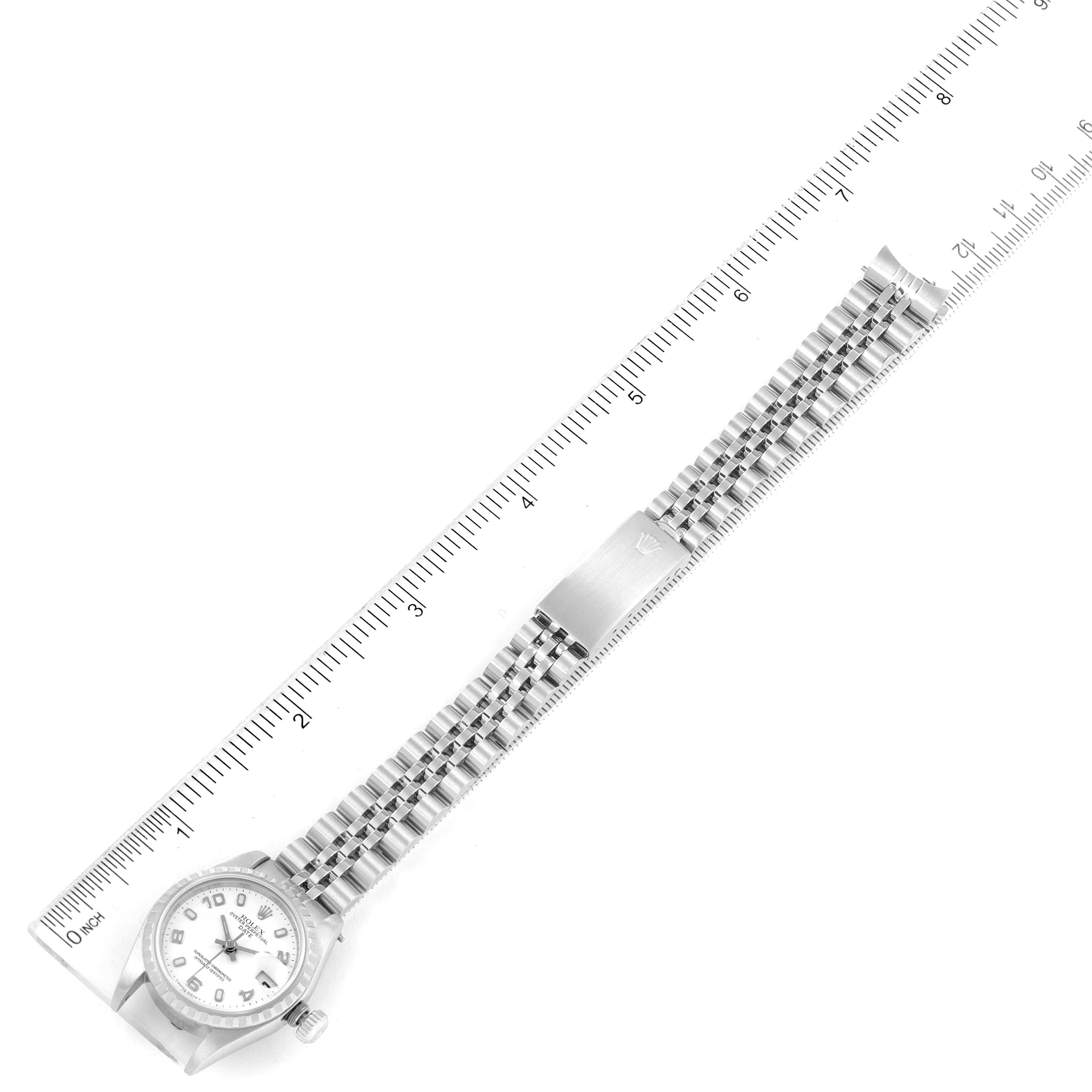 The image shows a Rolex Date 79240 Women's Stainless Steel White Dial 79240 Women's Stainless Steel White Dial model watch laid flat with a ruler to measure its length, showcasing the face, bracelet, and clasp.