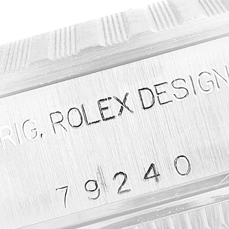 Close-up of a Rolex Date 79240 Women's Stainless Steel White Dial 79240 Women's Stainless Steel White Dial model's case, showing the engraved serial number and "ROLEX DESIGN" text.