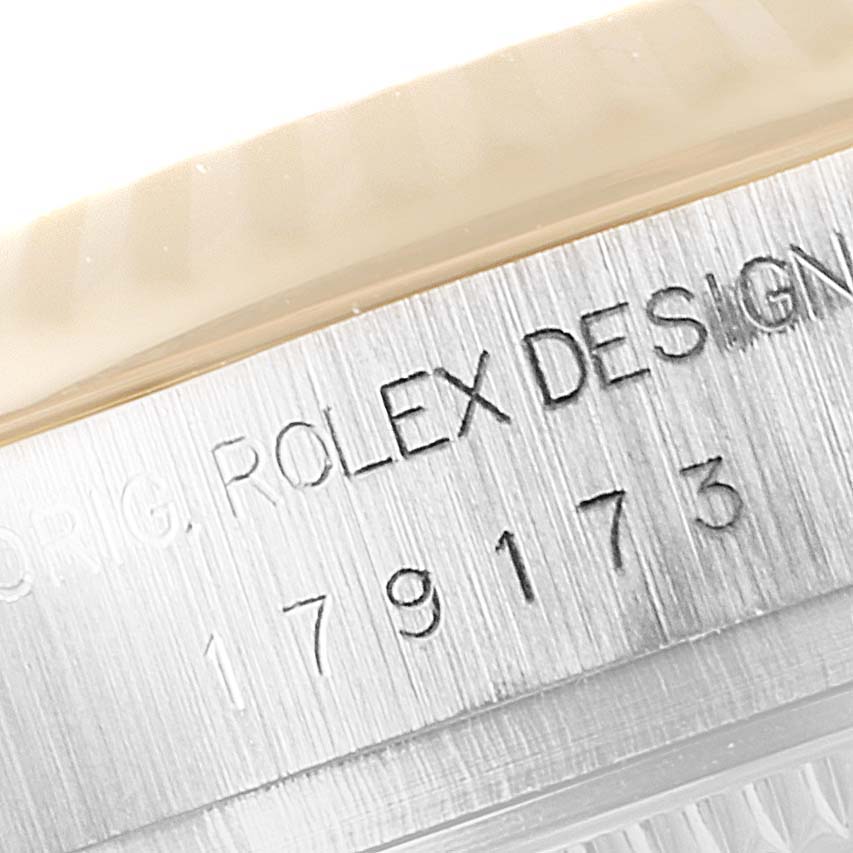 The image shows a close-up of the engraved serial number and "Rolex Design" on the case of a Rolex Datejust 179173 Women's Steel and Gold (two tone) Champagne Dial 179173 Women's Steel and Gold (two tone) Champagne Dial watch.