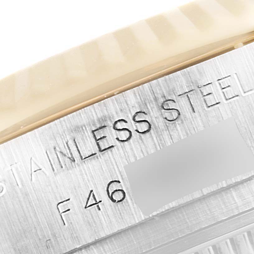 The image shows a close-up view of the side of a stainless steel Rolex Datejust 179173 Women's Steel and Gold (two tone) Champagne Dial 179173 Women's Steel and Gold (two tone) Champagne Dial watch, including part of the bezel and etched text.