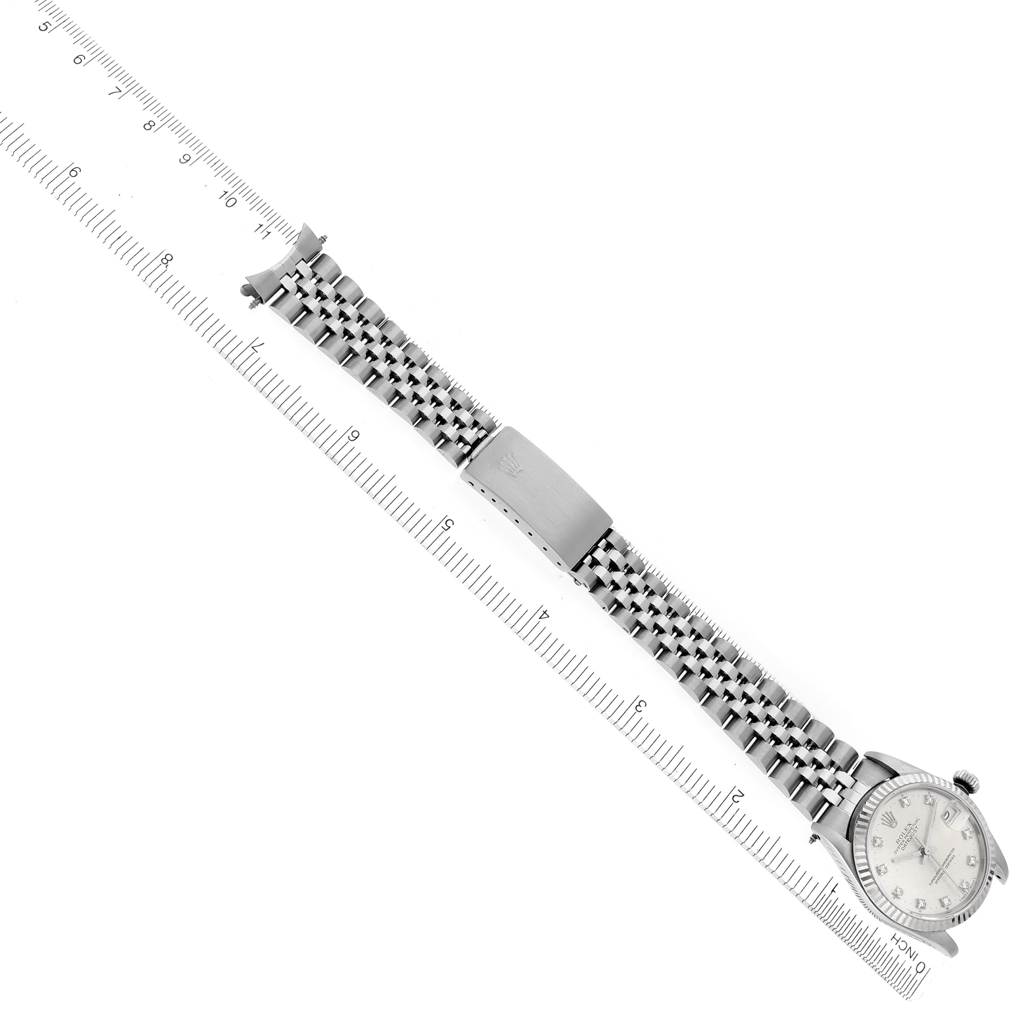 The Rolex Mid-Size 68274 Women's Stainless Steel Silver Dial 68274 Women's Stainless Steel Silver Dial watch is shown from a top-down angle with its full bracelet and clasp visible alongside a ruler for scale.