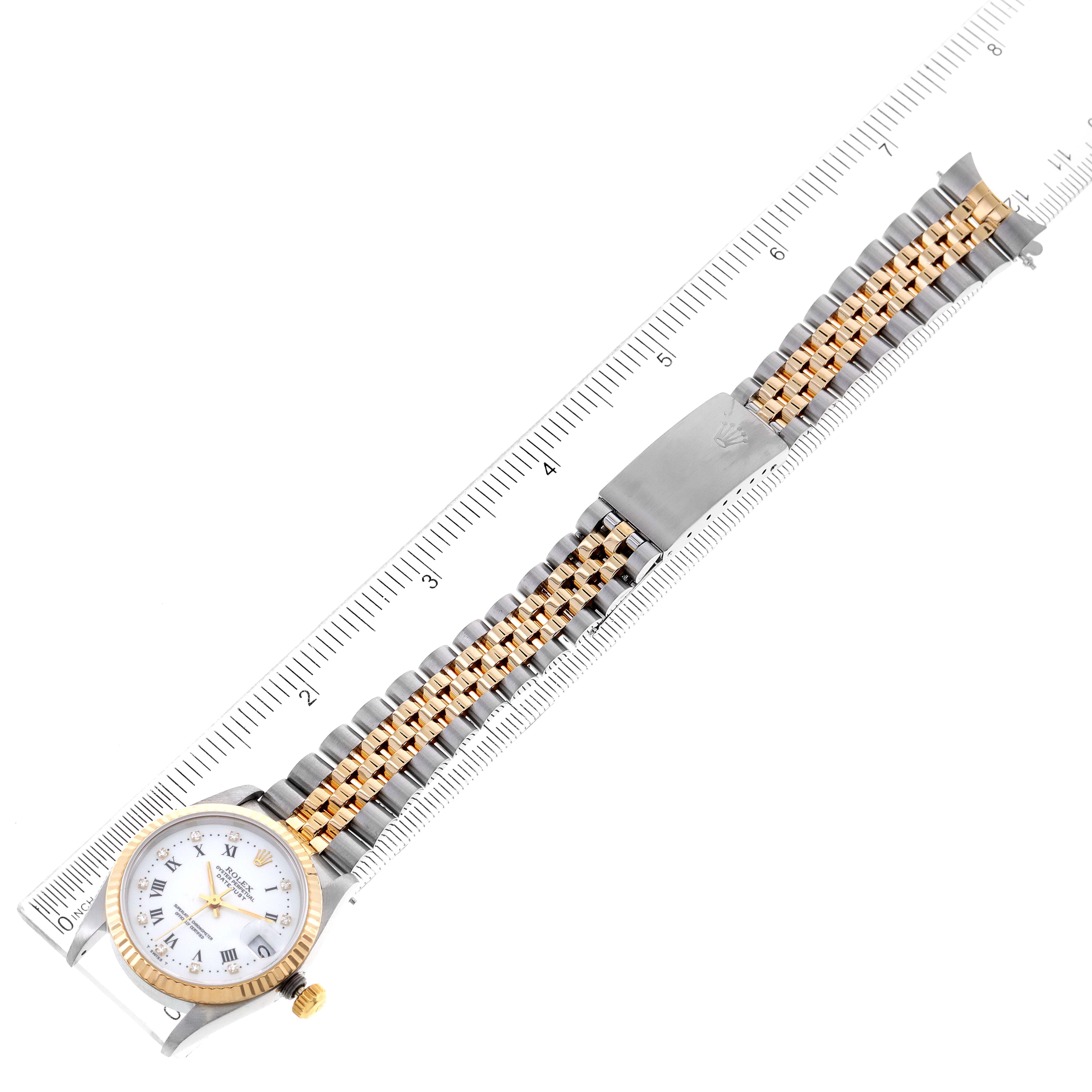 This image shows a top-down view of a Rolex Mid-Size 68273 Women
s Steel and Gold (two tone) White Dial 68273 Women
s Steel and Gold (two tone) White Dial model watch with its band placed along a ruler.