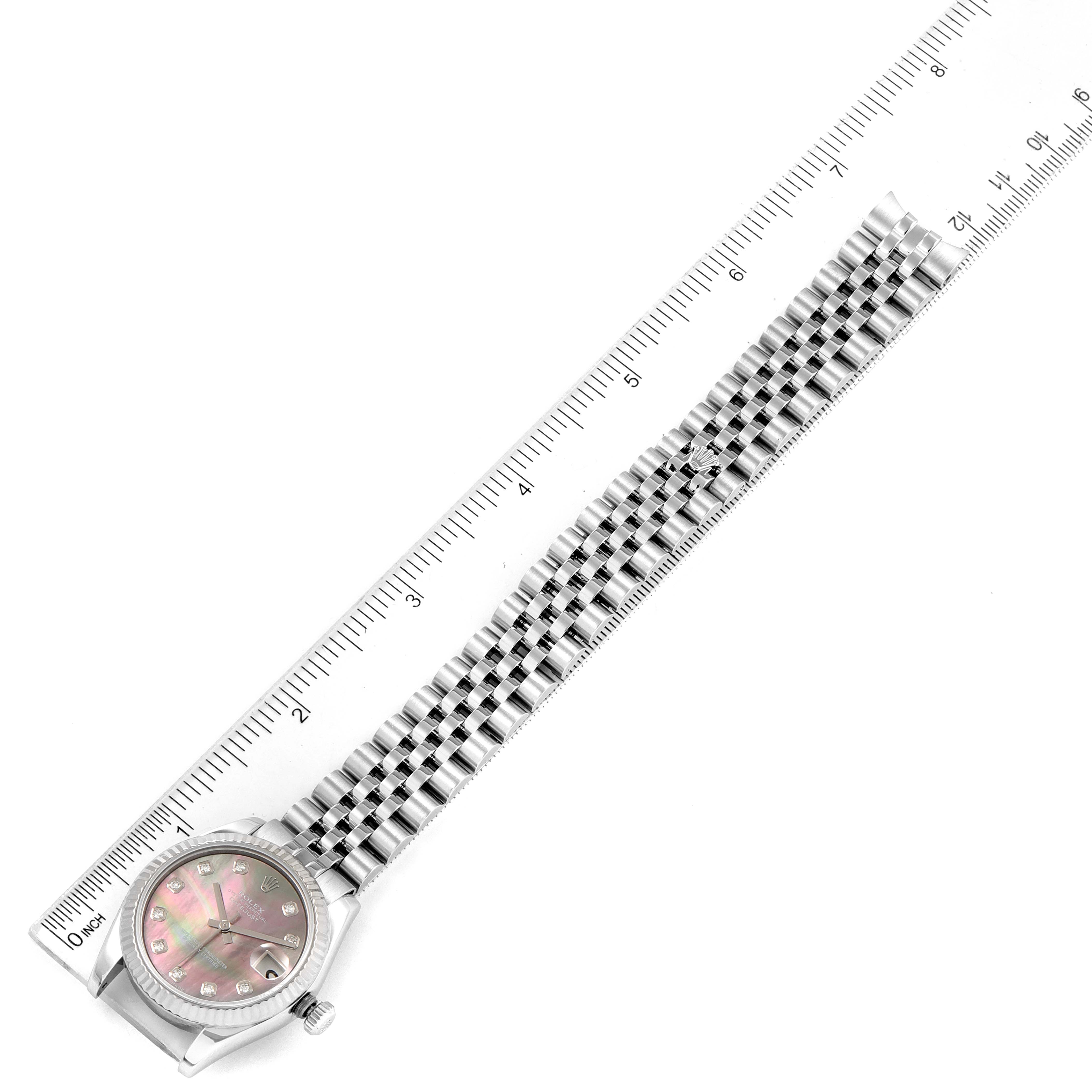 The image shows a top-down view of a Rolex Mid-Size 178274 Women's Stainless Steel Mother of Pearl Dial 178274 Women's Stainless Steel Mother of Pearl Dial watch, including its face and bracelet, next to a ruler for scale.