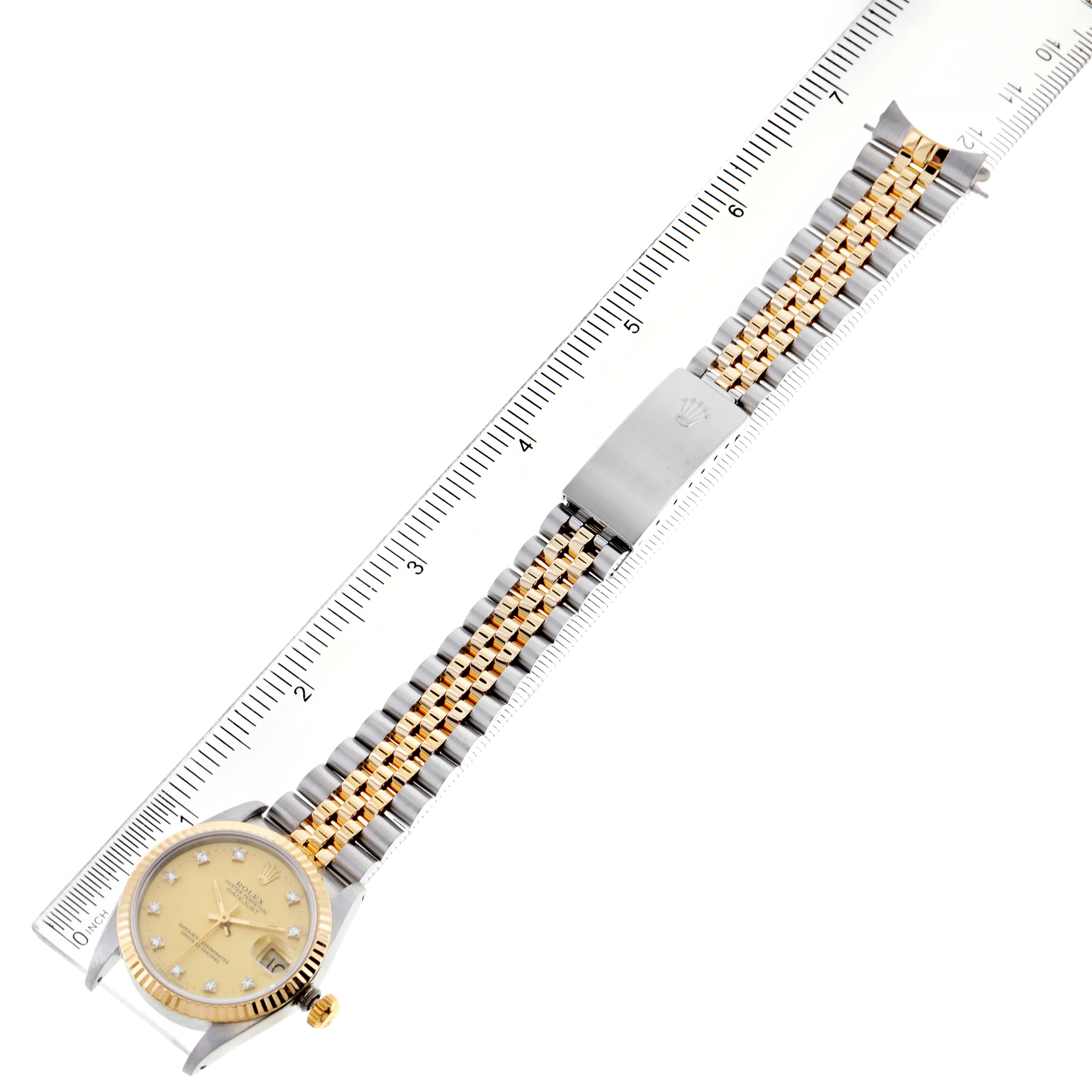 The image shows a top-down view of a Rolex Mid-Size 68273 Women's Steel and Gold (two tone) Champagne Dial 68273 Women's Steel and Gold (two tone) Champagne Dial watch, featuring its dial, bezel, and two-tone bracelet placed against a ruler.