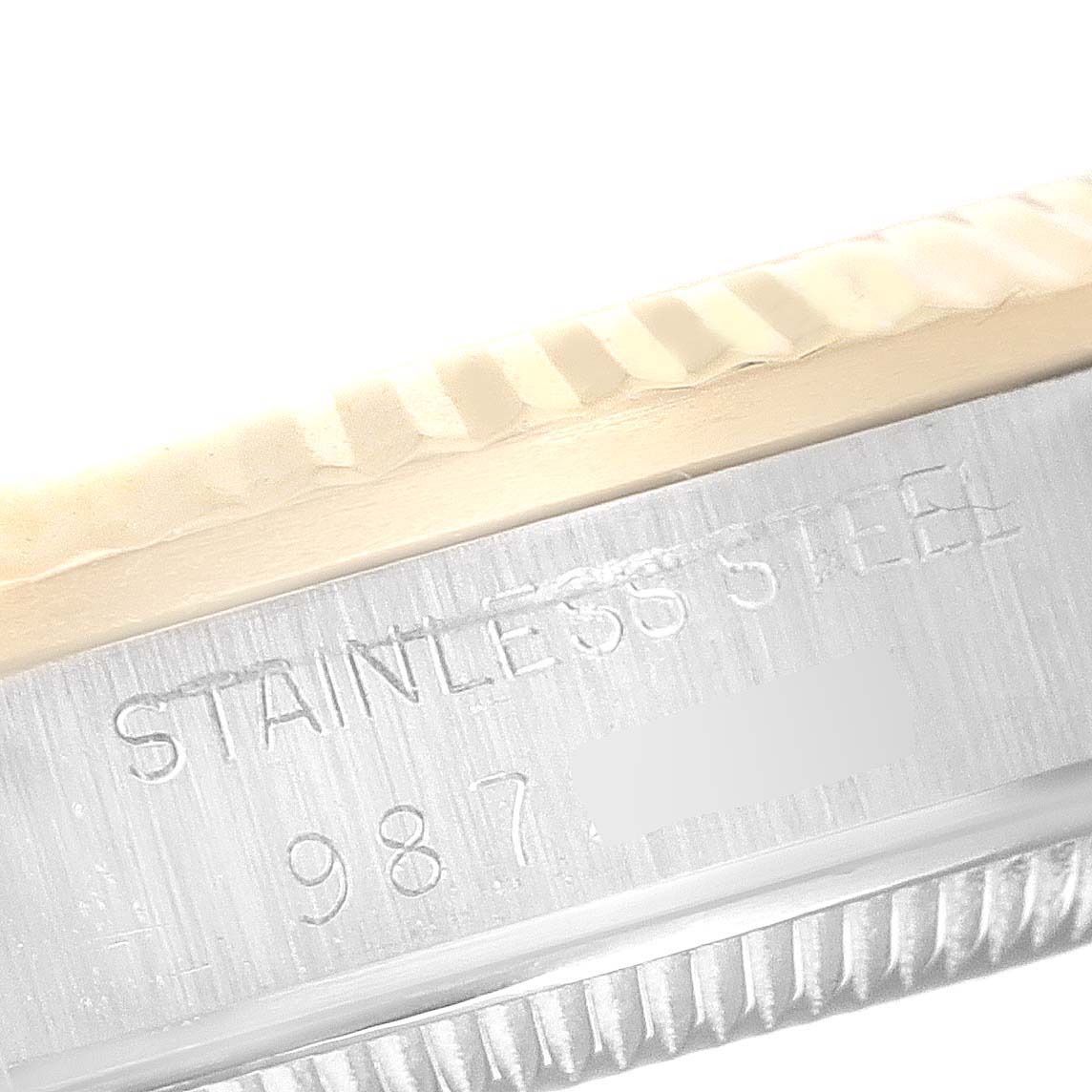 The image shows a close-up of the bezel and case side of a Mid-Size Rolex watch, highlighting the "STAINLESS STEEL" engraving.