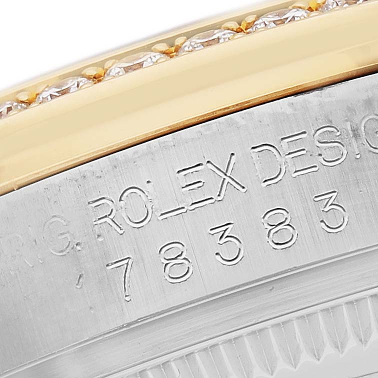 The image shows an angled close-up of the engraved side of a Mid-Size Rolex watch case with a decorative bezel above.
