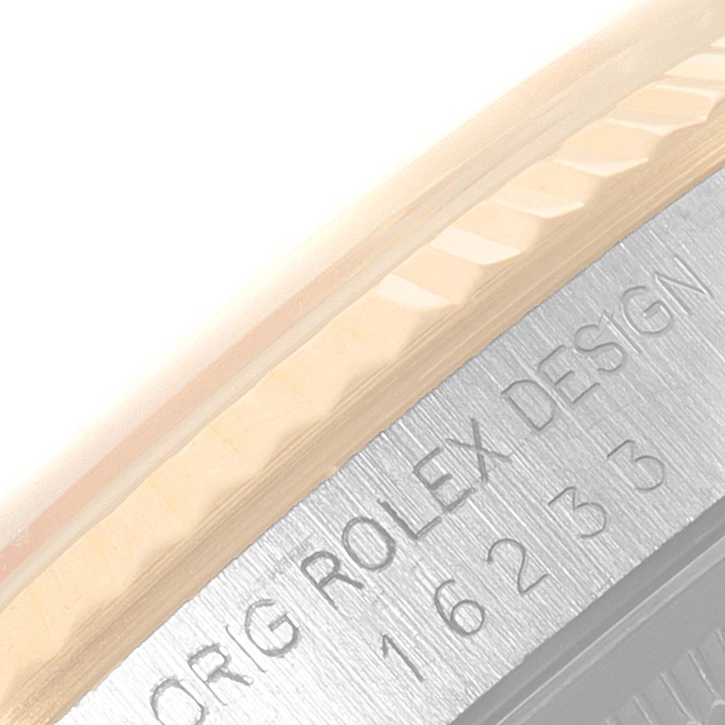 This close-up image shows part of the bezel and engraved case back of a Rolex Datejust 16233 Men's Steel and Gold (two tone) Champagne Dial 16233 Men's Steel and Gold (two tone) Champagne Dial watch.