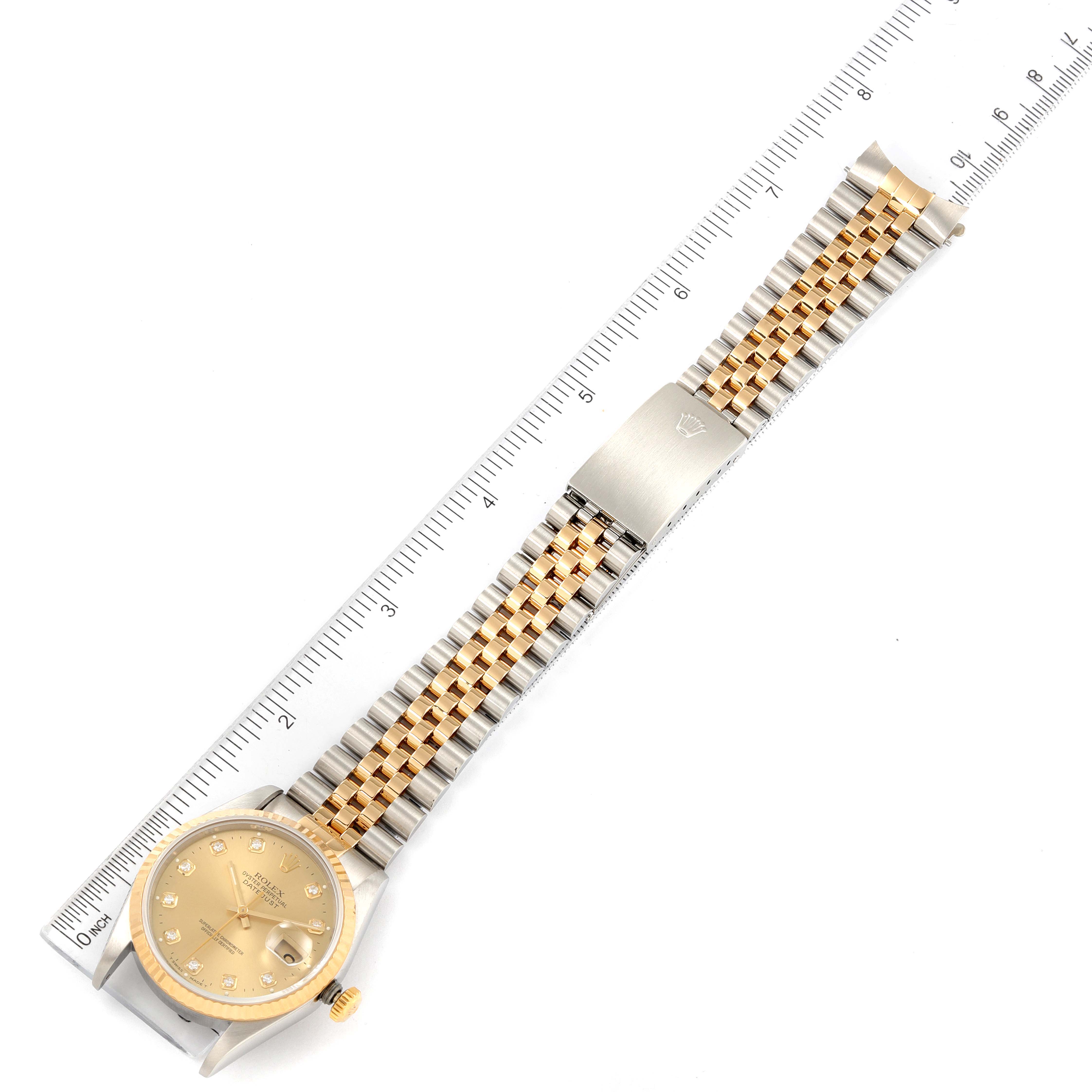 The image shows a Rolex Datejust 16233 Men's Steel and Gold (two tone) Champagne Dial 16233 Men's Steel and Gold (two tone) Champagne Dial watch with a gold dial, a two-tone bracelet, and a ruler indicating the watch's length.