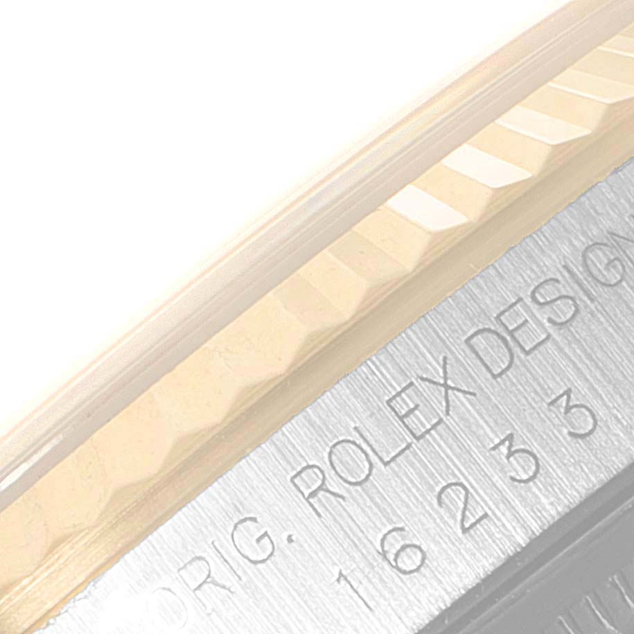 This close-up image shows the fluted bezel and part of the engraved case of a Rolex Datejust 16233 Men's Steel and Gold (two tone) Champagne Dial 16233 Men's Steel and Gold (two tone) Champagne Dial watch.