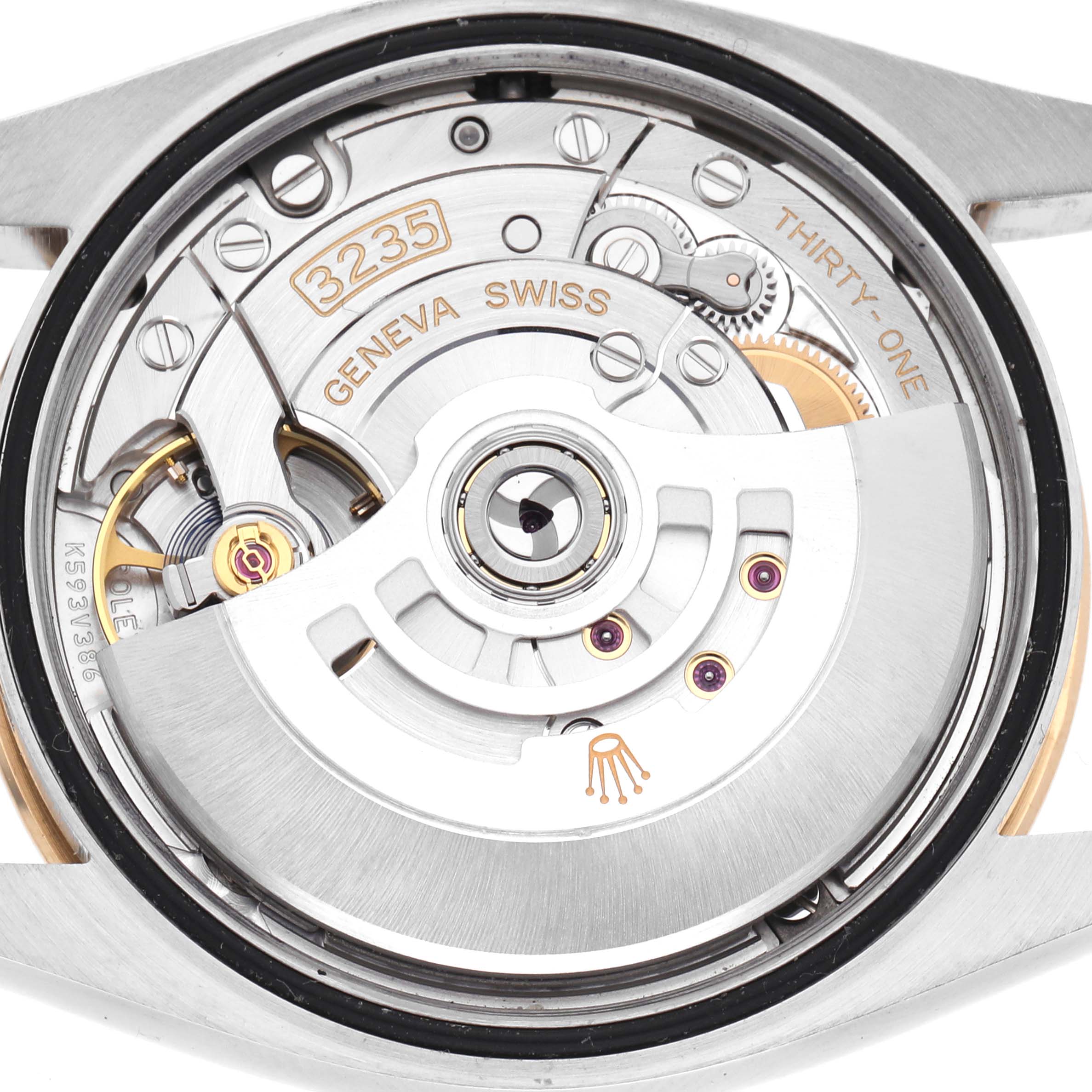 The image shows the movement of a Rolex Datejust 126233 Men's Steel and Gold (two tone) Champagne Dial 126233 Men's Steel and Gold (two tone) Champagne Dial watch viewed from the back, highlighting its intricate components and rotor.