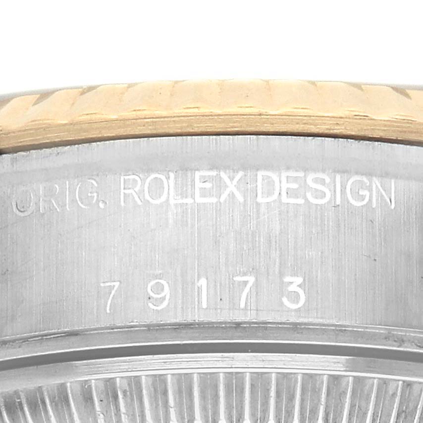 The image shows a close-up of the side engraving on the Rolex Datejust 79173 Women's Steel and Gold (two tone) Champagne Dial 79173 Women's Steel and Gold (two tone) Champagne Dial watch, detailing "ORIG. ROLEX DESIGN" and model number "79173."