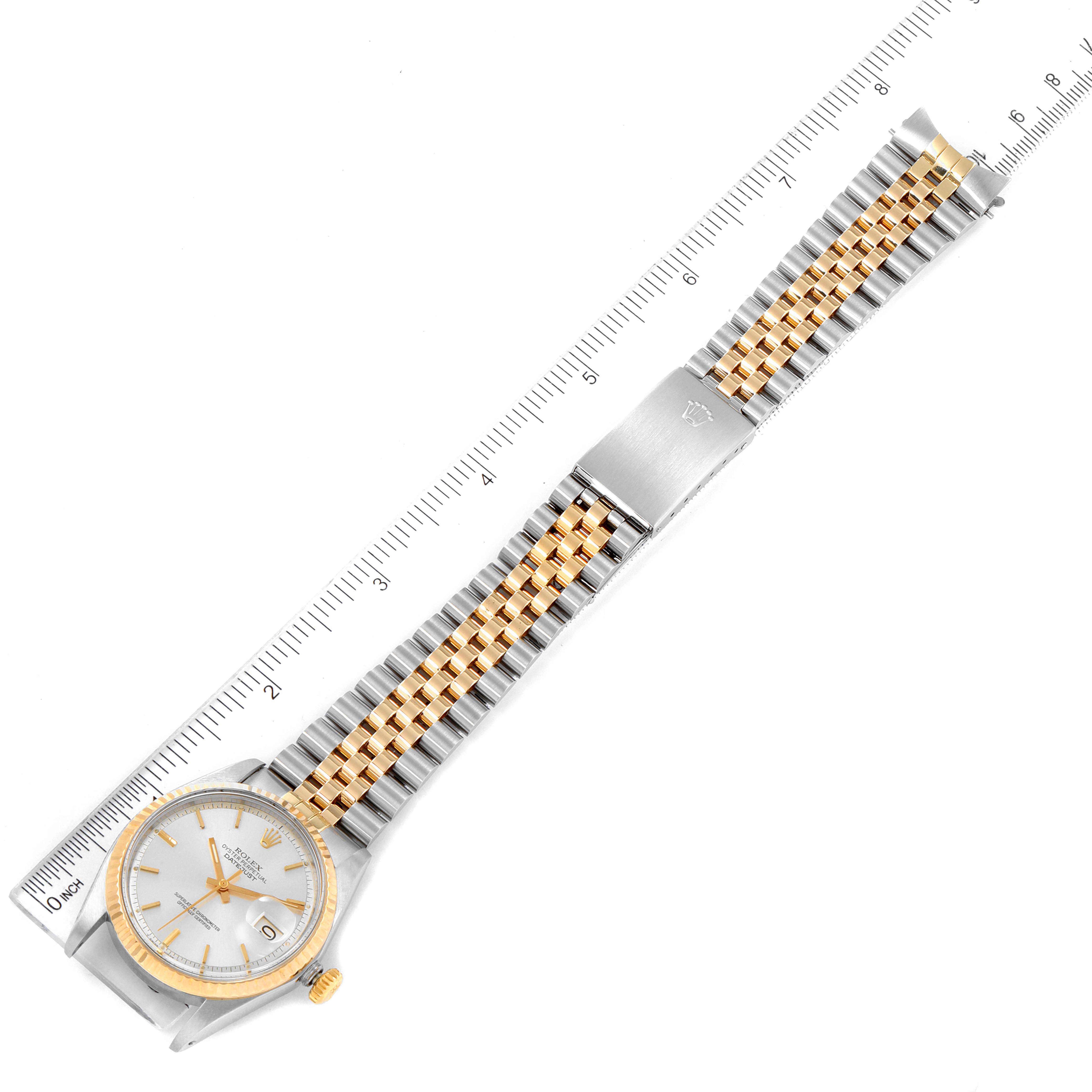 The Vintage Collection Rolex watch is shown laid flat with a ruler, displaying the full watch face and metal strap.
