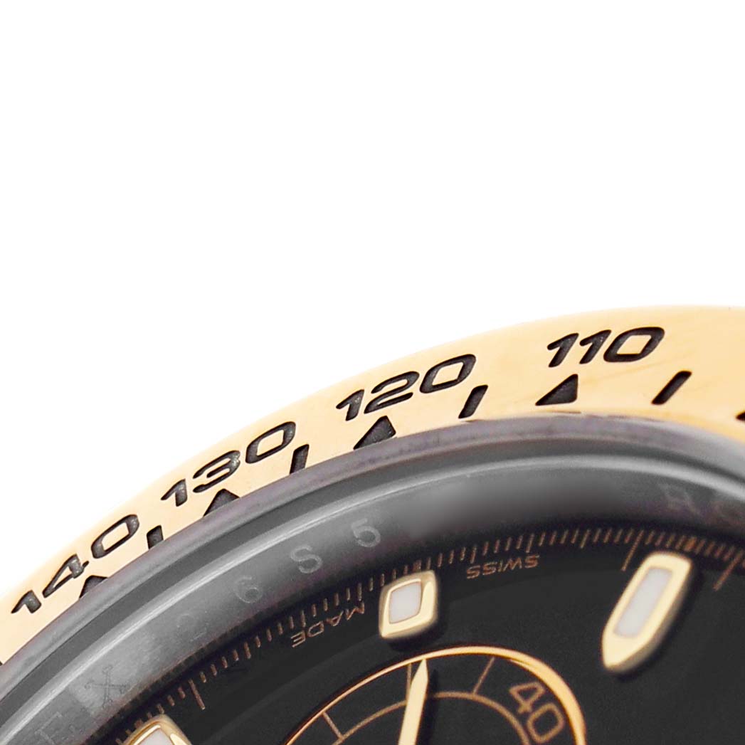 The image shows a close-up of the bezel and part of the dial of a Rolex Daytona 116503 Men's Steel and Gold (two tone) Black Dial watch, highlighting the tachymetric scale.