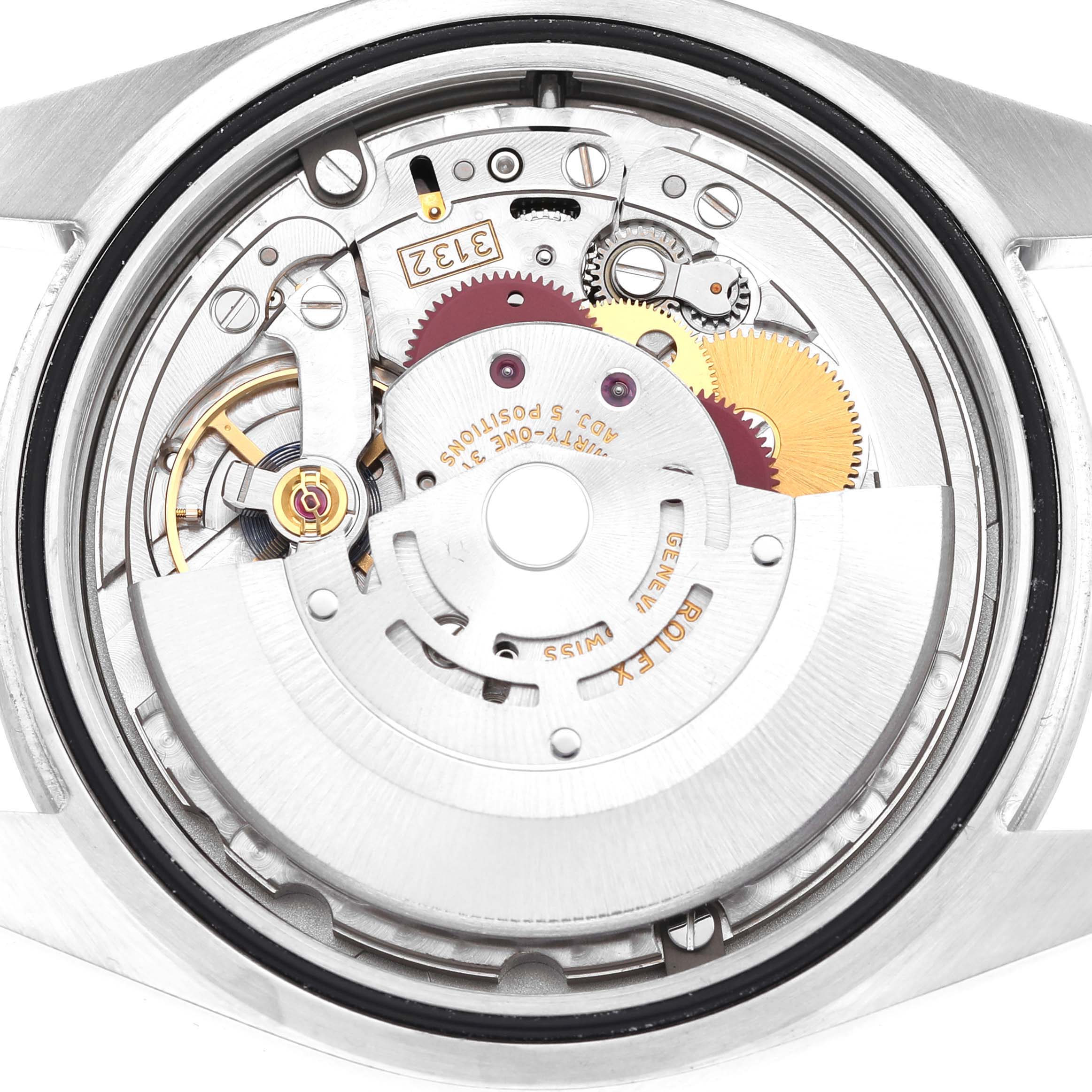 The image shows the movement from the back of a Rolex Explorer 214270 Men's Stainless Steel Black Dial watch, highlighting gears and mechanisms.