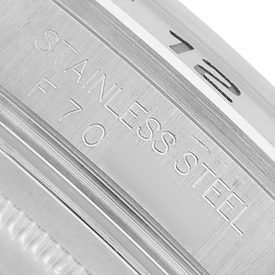 The image shows a close-up of the stainless steel engraving on the case back edge of a Rolex Explorer 16570 Men's Stainless Steel Black Dial watch.