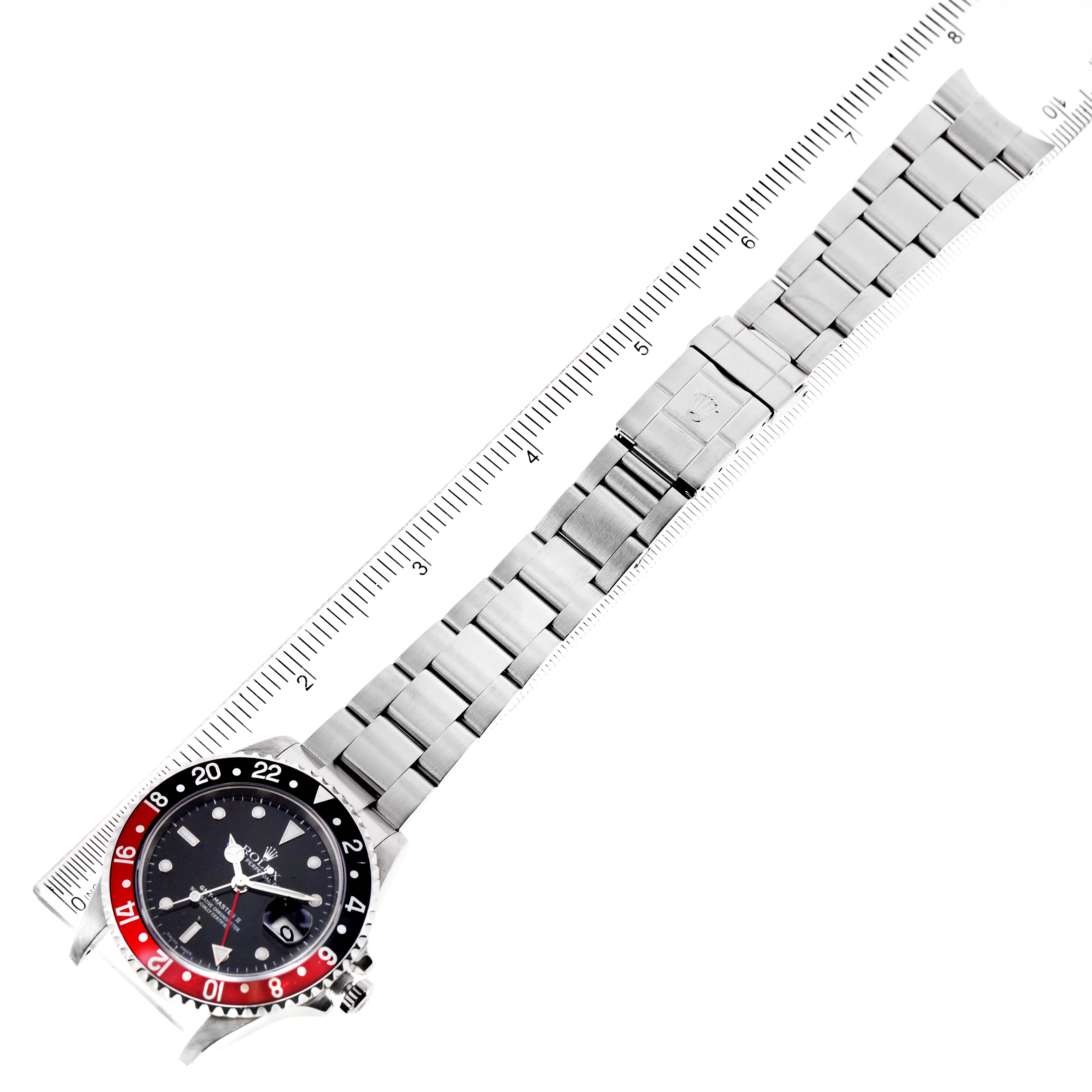 The image shows a top-down view of the Rolex GMT-Master 16710 Men's Stainless Steel Black Dial 16710 Men's Stainless Steel Black Dial watch with bracelet extended next to a ruler.