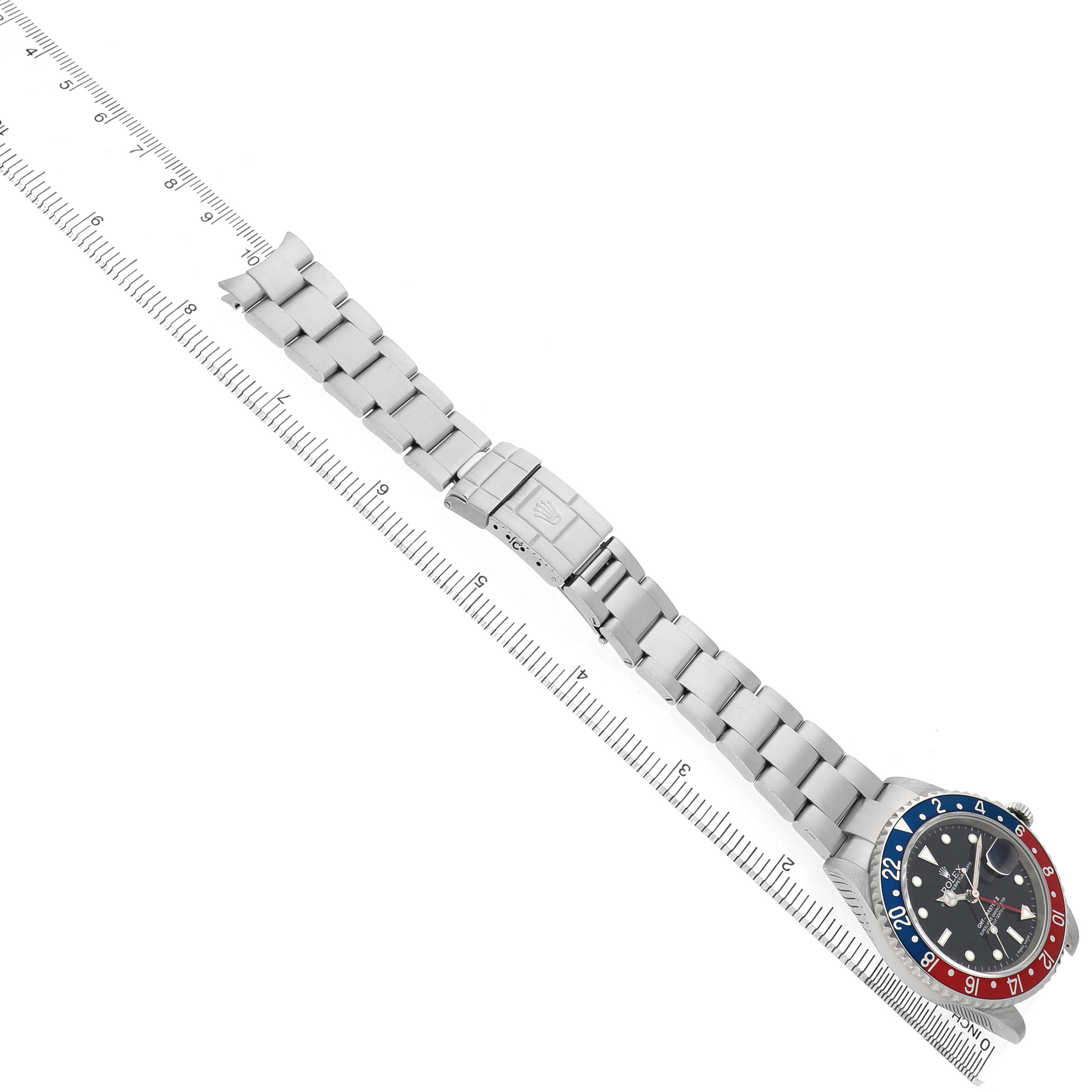 The Rolex GMT-Master 16710 Men's Stainless Steel Black Dial watch is shown from a top view, displaying the bezel, dial, bracelet, and clasp alongside a ruler.