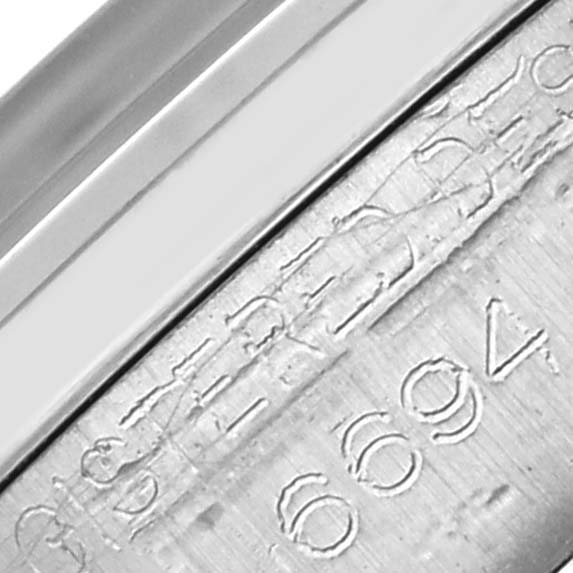The image shows a close-up of the Rolex Date 6694 Men's Stainless Steel Silver Dial 6694 Men's Stainless Steel Silver Dial model's bezel and part of the engraved case.