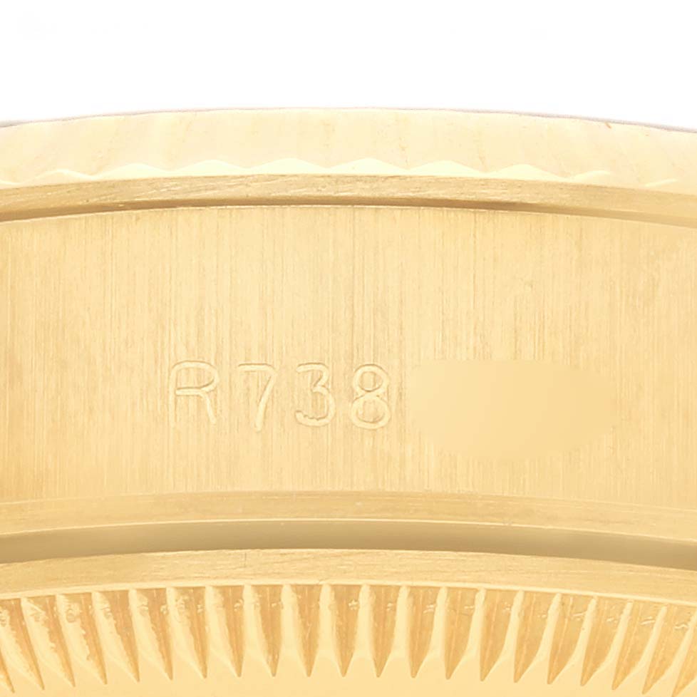 The image shows a close-up of the Rolex President 69178 Women's Yellow Gold Champagne Dial 69178 Women's Yellow Gold Champagne Dial watch's bezel and edge with engraved markings.