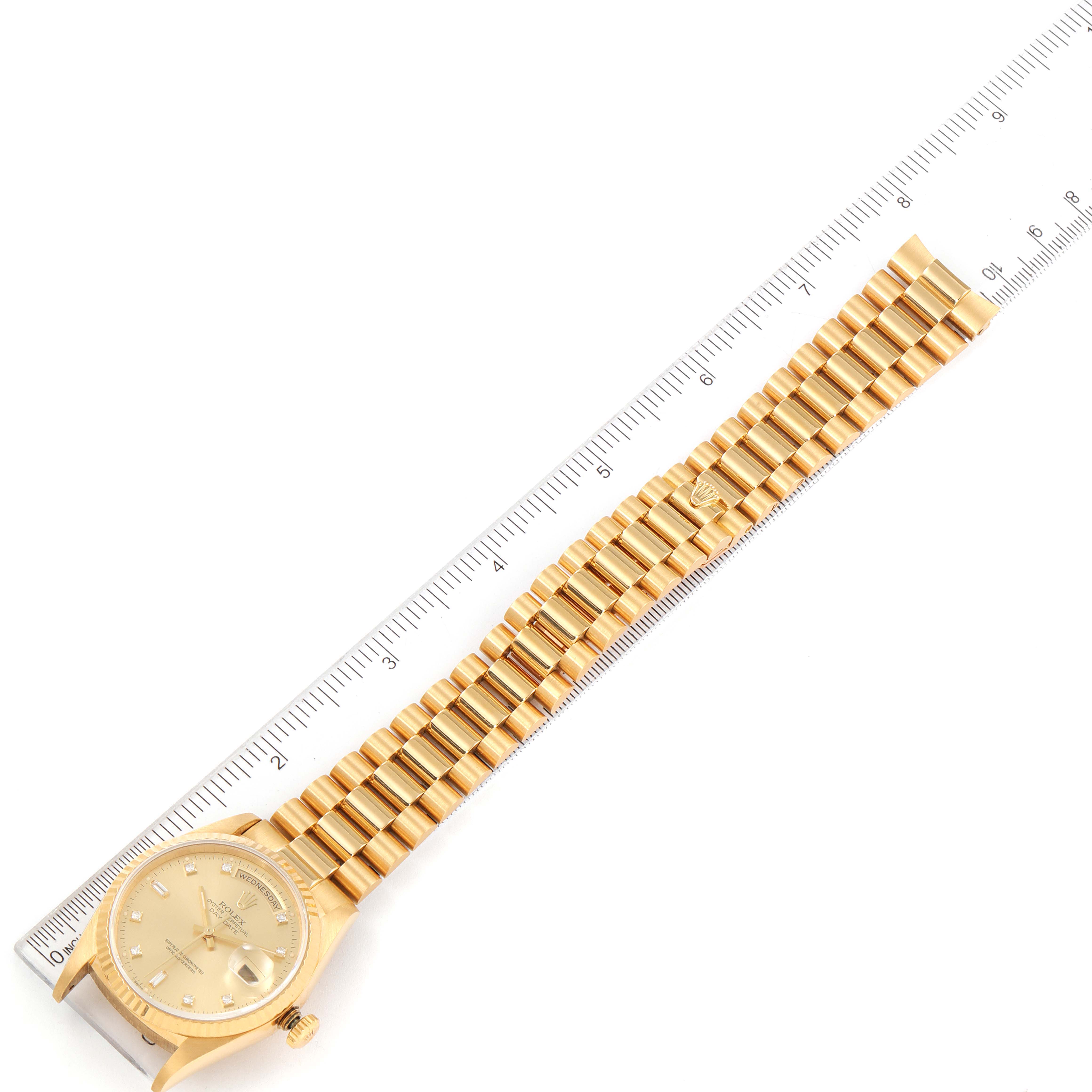 This image shows a Rolex President 18238 Men
s Yellow Gold Champagne Dial 18238 Men
s Yellow Gold Champagne Dial model watch laid flat with the face, crown, and bracelet visible next to a ruler for scale.