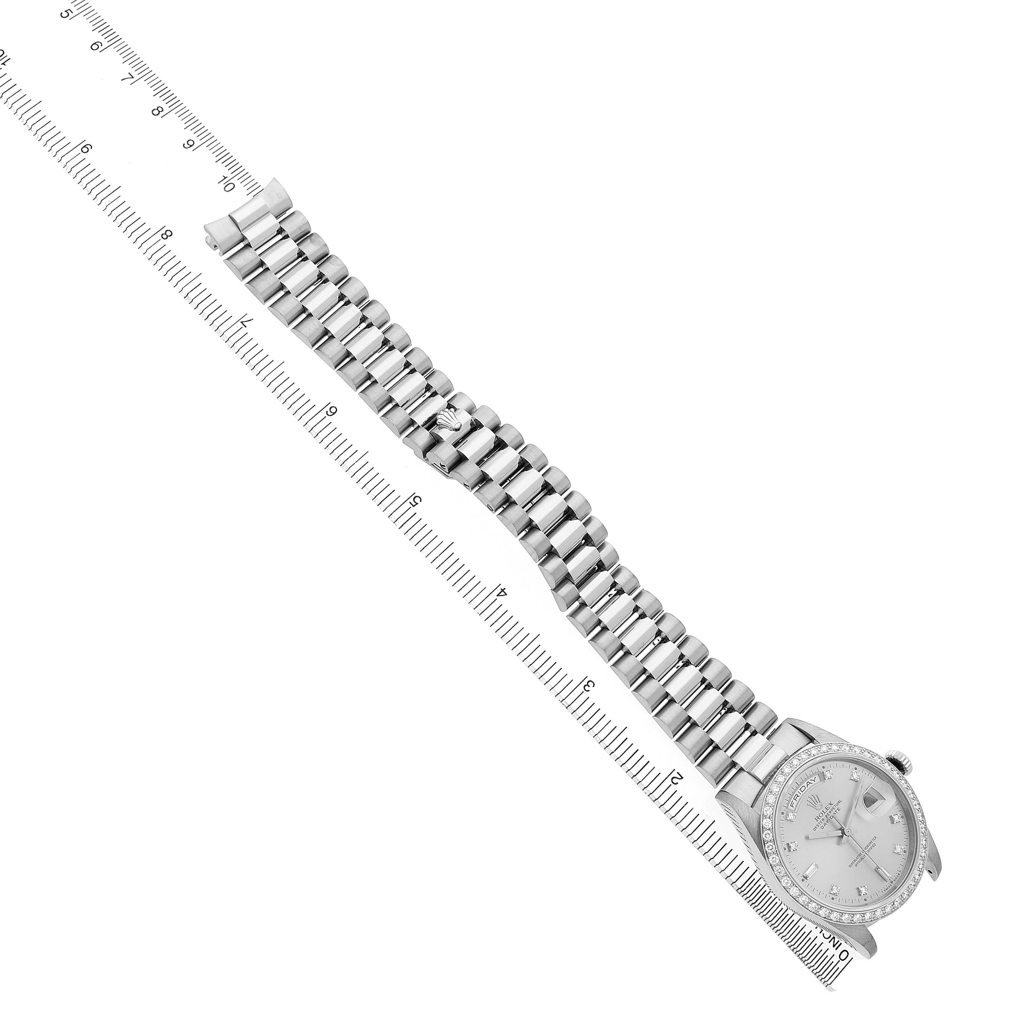 The Rolex President 18349 Men's White Gold Silver Dial watch is shown from a top-down angle with its bracelet fully extended beside a ruler.