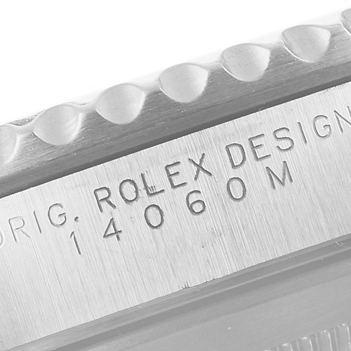 The image shows a close-up view of the case side of a Rolex Submariner 14060M Men
s Stainless Steel Black Dial 14060M Men
s Stainless Steel Black Dial, displaying its engraved model number and edge of the bezel.