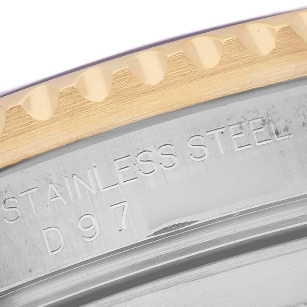 The image shows a close-up of a Rolex Submariner 16613 Men's Steel and Gold (two tone) Blue Dial 16613 Men's Steel and Gold (two tone) Blue Dial's side, displaying the edge of the bezel and engraved text on the casing.