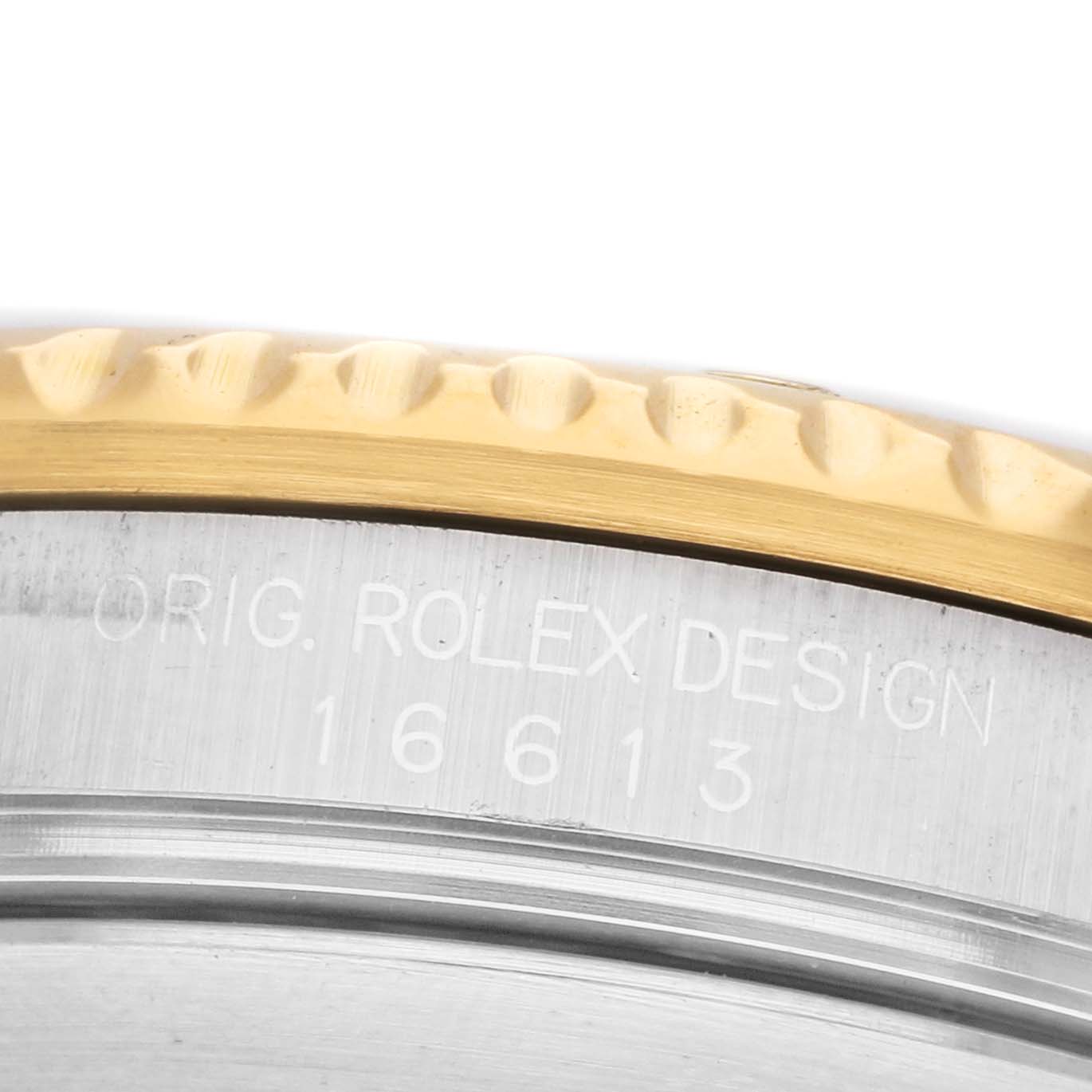 The image shows a close-up of the Rolex Submariner 16613 Men's Steel and Gold (two tone) Blue Dial's case, featuring its engraved model number and part of the bezel.