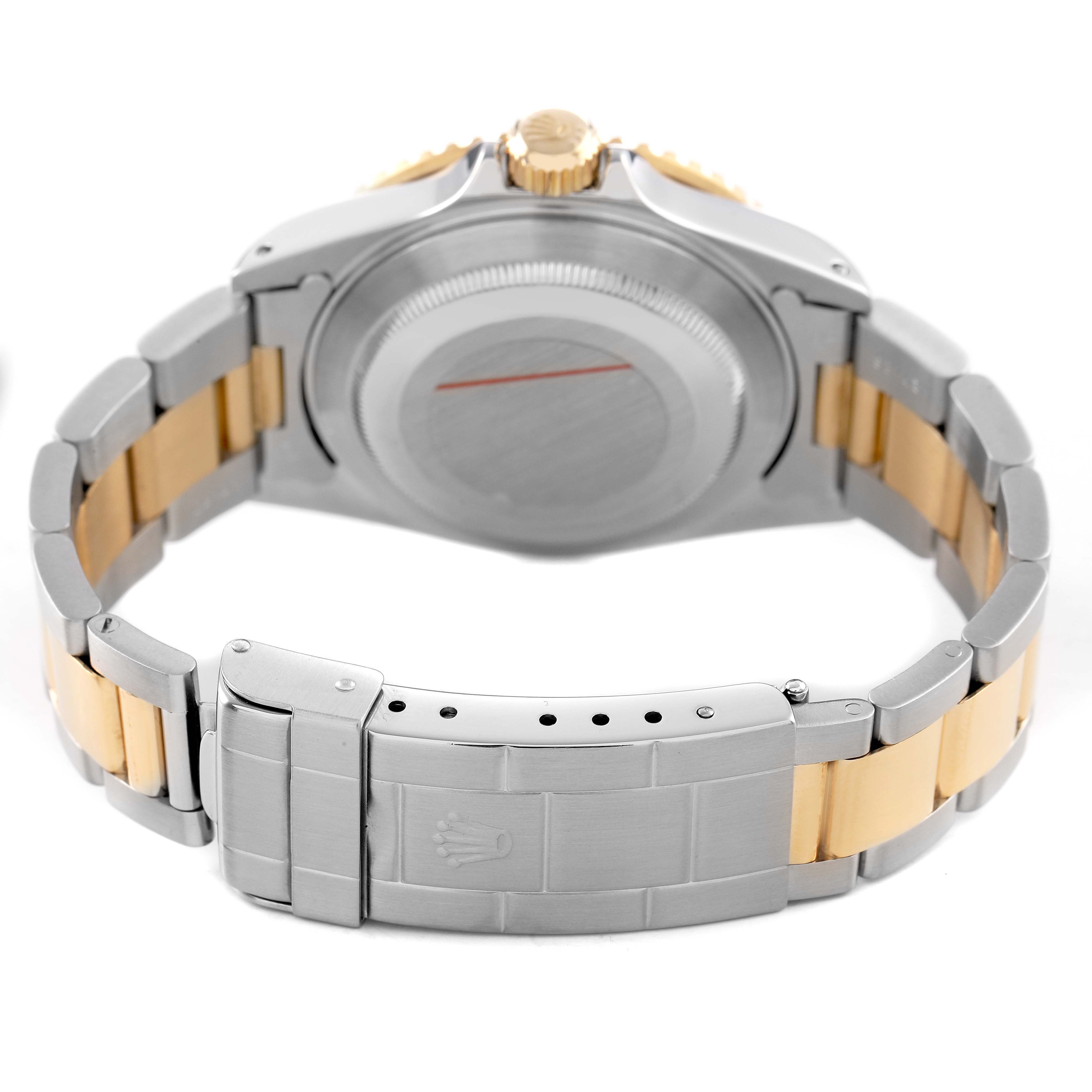 The Rolex Submariner 16613 Men's Steel and Gold (two tone) Silver Dial is shown from the back, highlighting its case back, bracelet, and clasp.