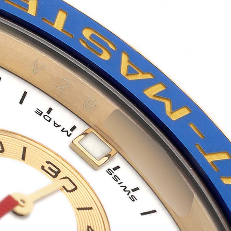 The image shows a close-up of the Rolex Yacht-Master 116688 Men's Yellow Gold White Dial's bezel, partial dial, and hour markers.