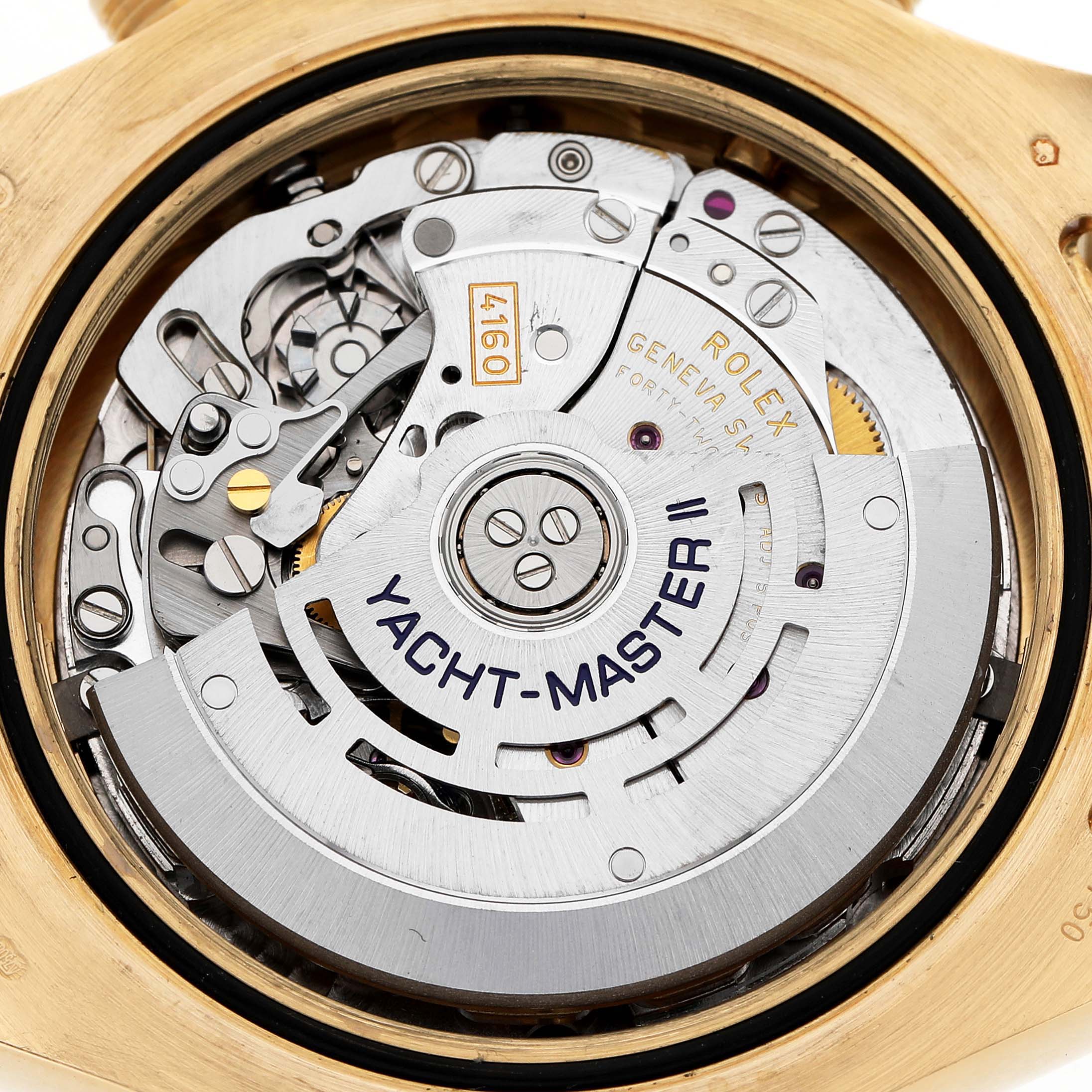 The image shows the movement of a Rolex Yacht-Master 116688 Men's Yellow Gold White Dial II watch from the back, highlighting its intricate mechanics.