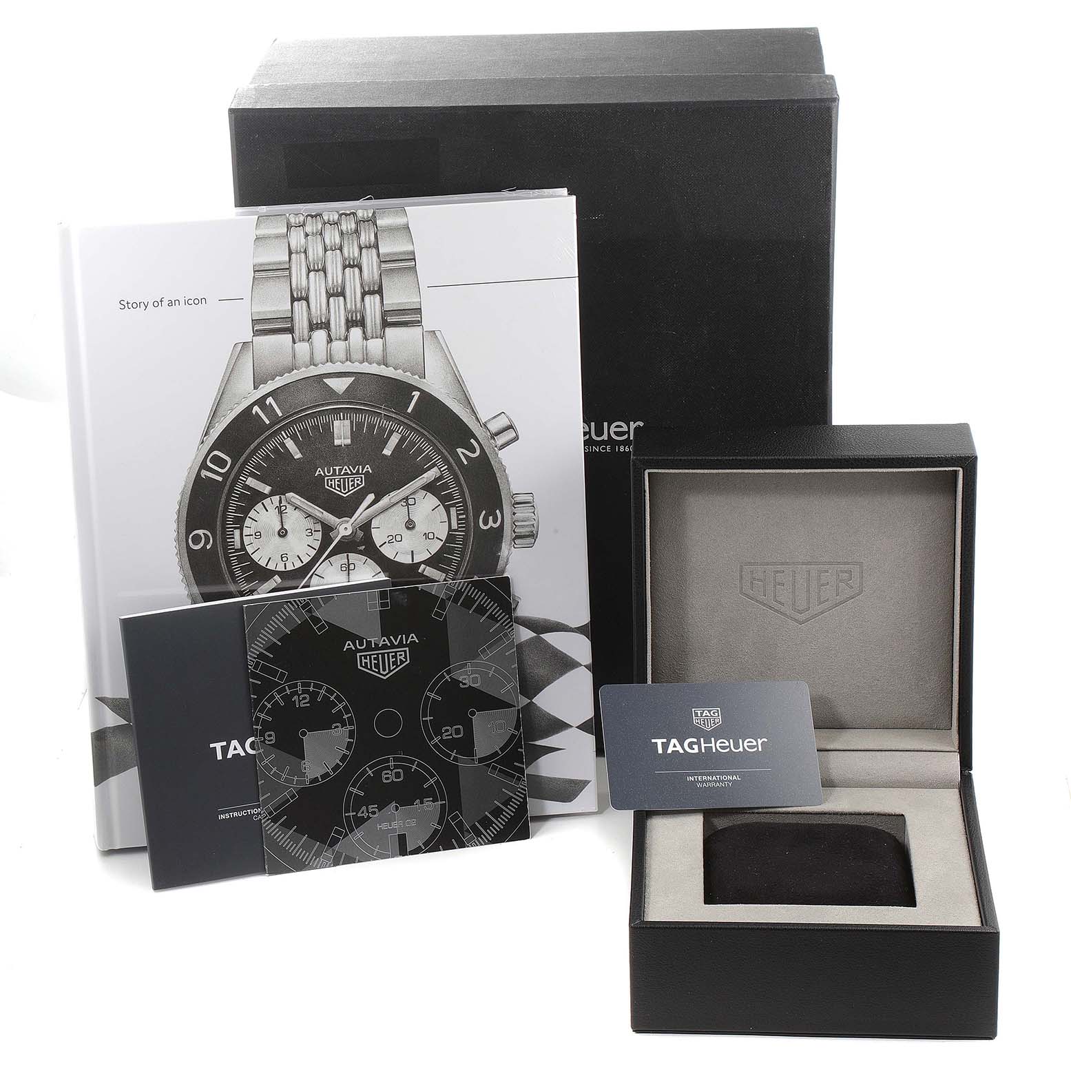 The image displays the packaging, manuals, and presentation box for a TAG Heuer Autavia watch, with no watch visible.