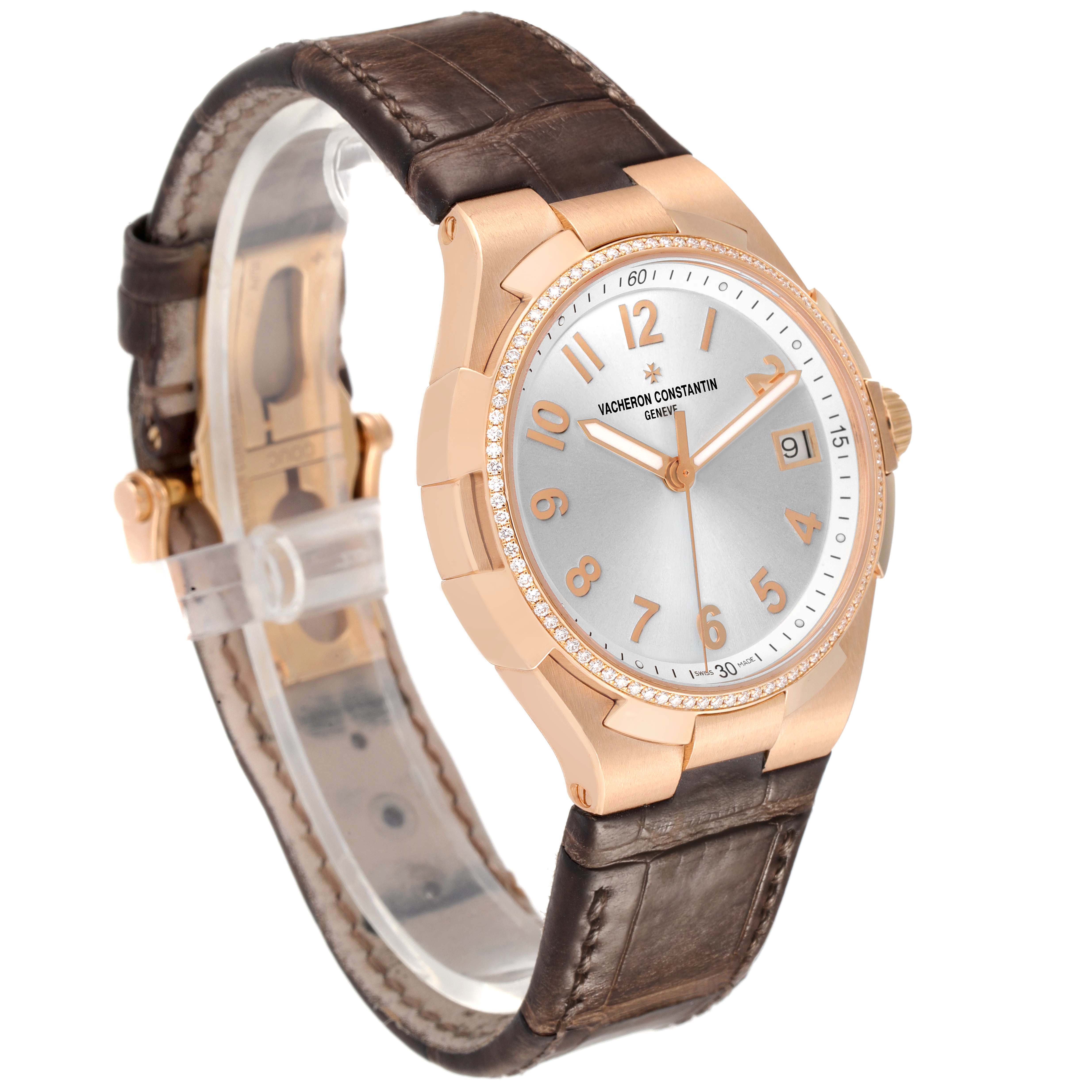 The Vacheron Constantin Overseas 47560/000R-9672 Women's Rose Gold Silver Dial watch is shown at an angled side view, highlighting the face, numbers, and brown leather strap.