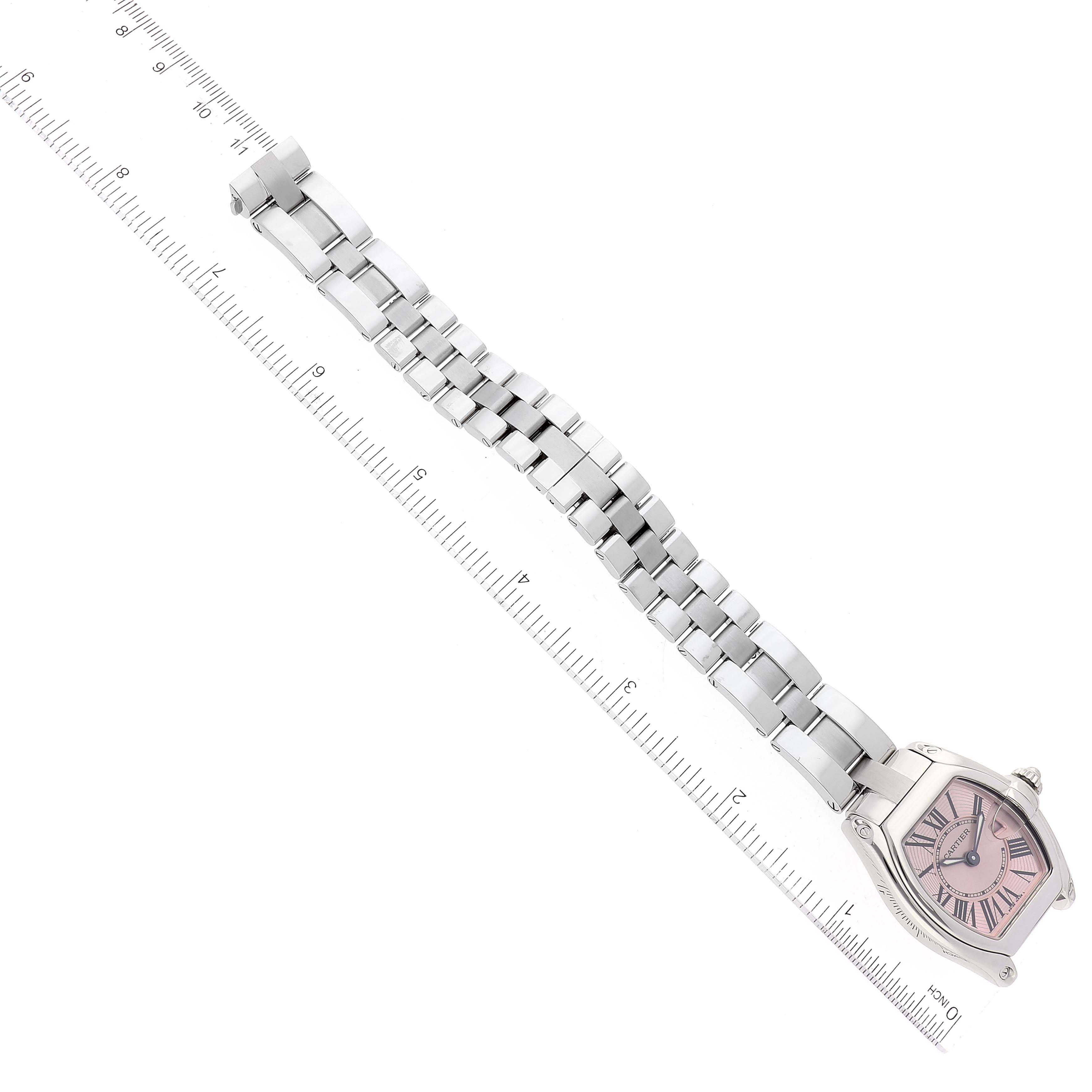 This image shows a Cartier Roadster W62017V3 Women's Stainless Steel Pink Dial W62017V3 Women's Stainless Steel Pink Dial watch at a top-down angle, highlighting its face, bracelet, and a measuring ruler beside it.