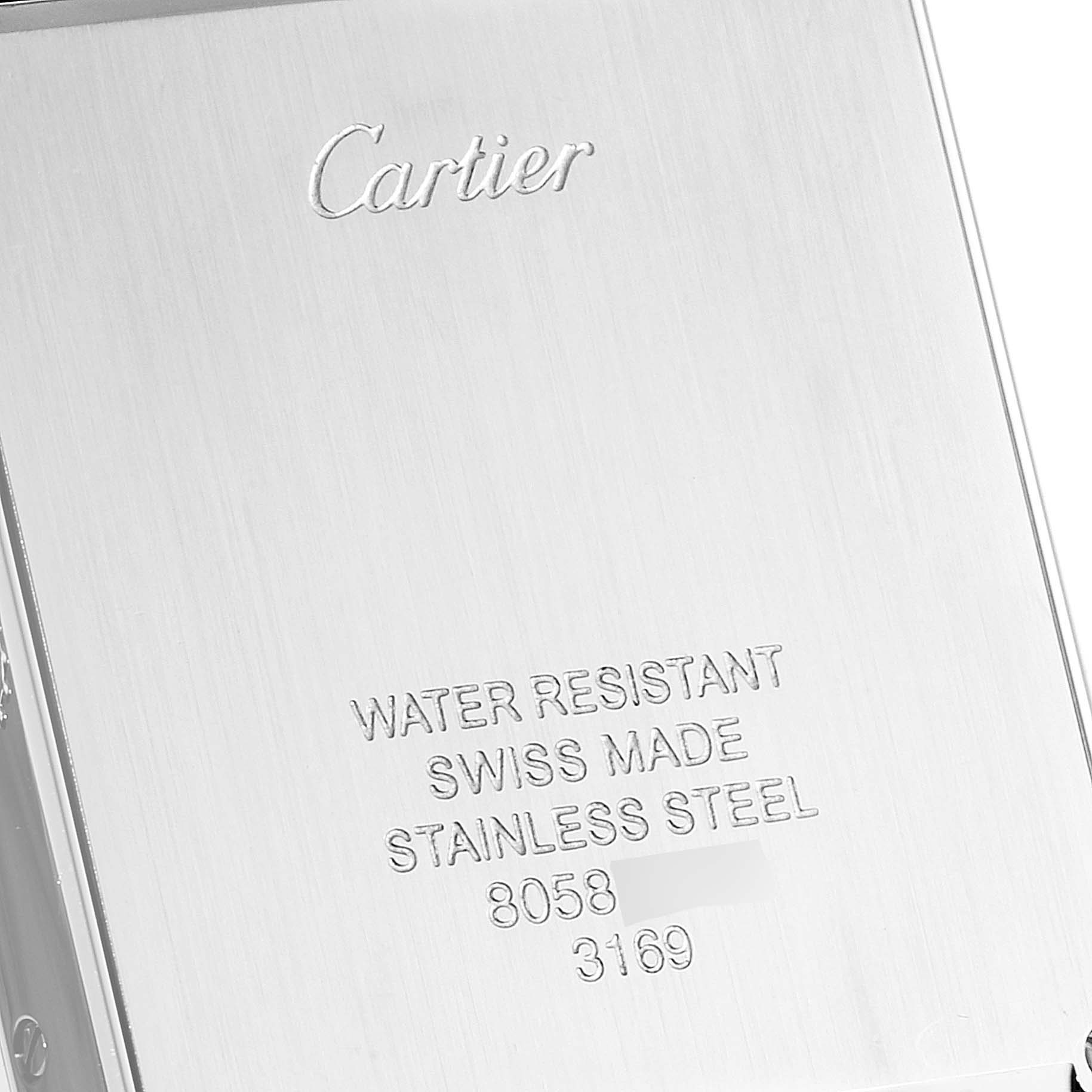 This image shows the back case of a Cartier Tank Solo W5200014 Men's Stainless Steel Silver Dial W5200014 Men's Stainless Steel Silver Dial watch with engraved text.